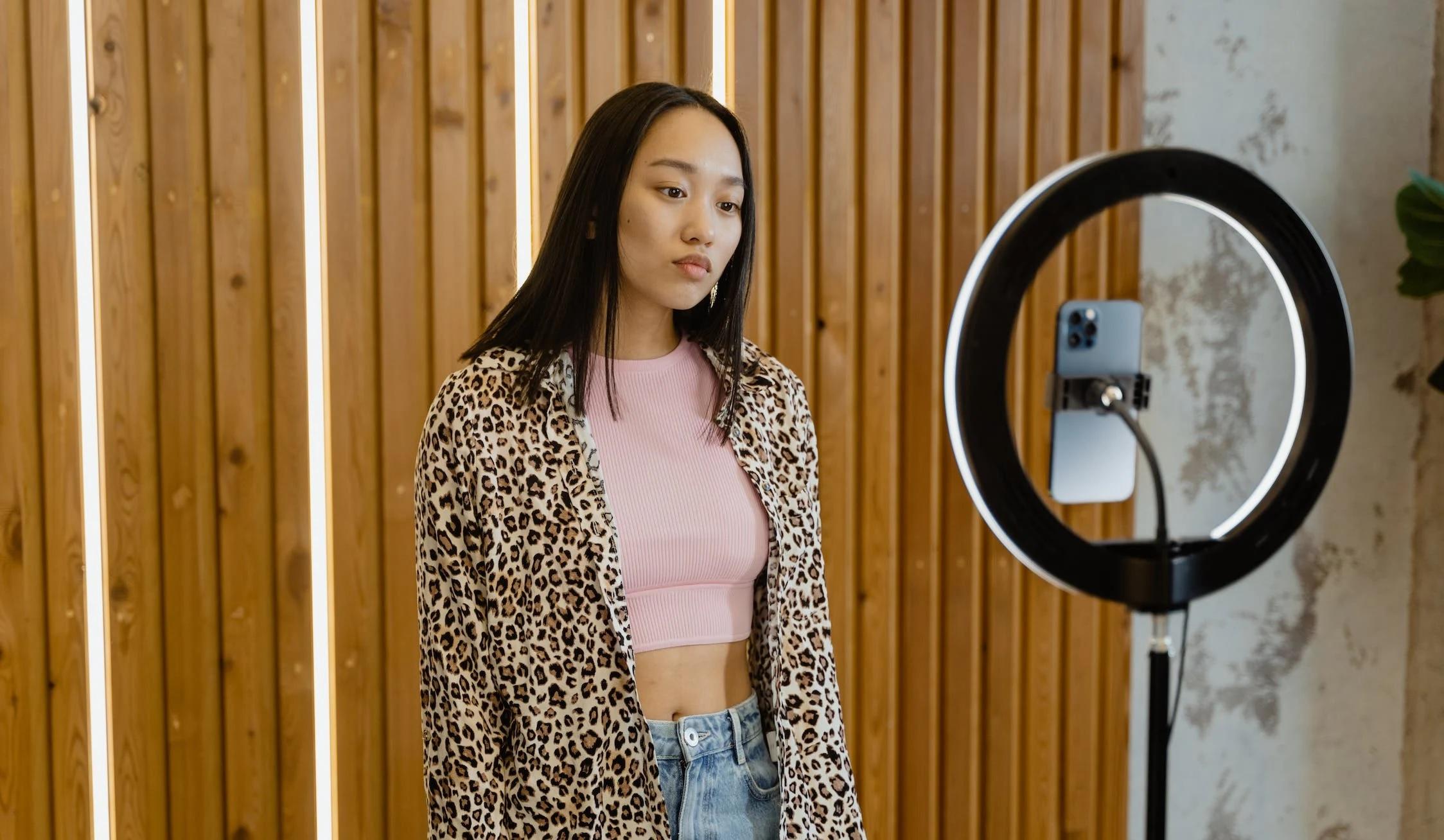 Une influenceuse se préparer à parler devant son smartphone.