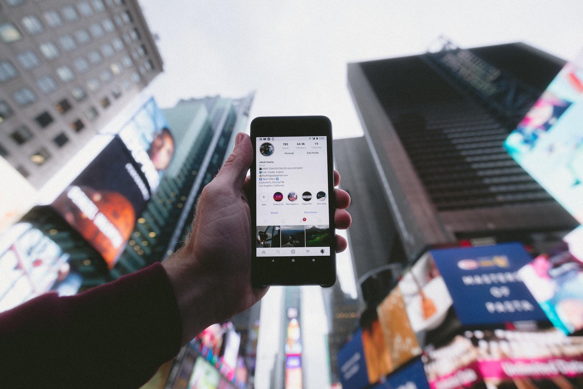 un influenceur tenant son téléphone dans une grande ville avec des buildings