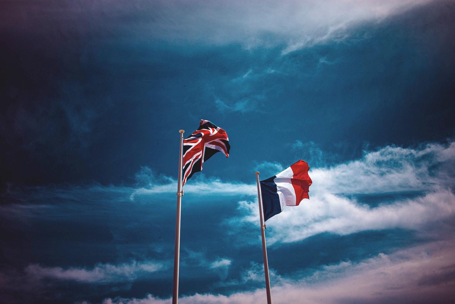 1 drapeau anglais et 1 drapeau français flottent côte à côte.