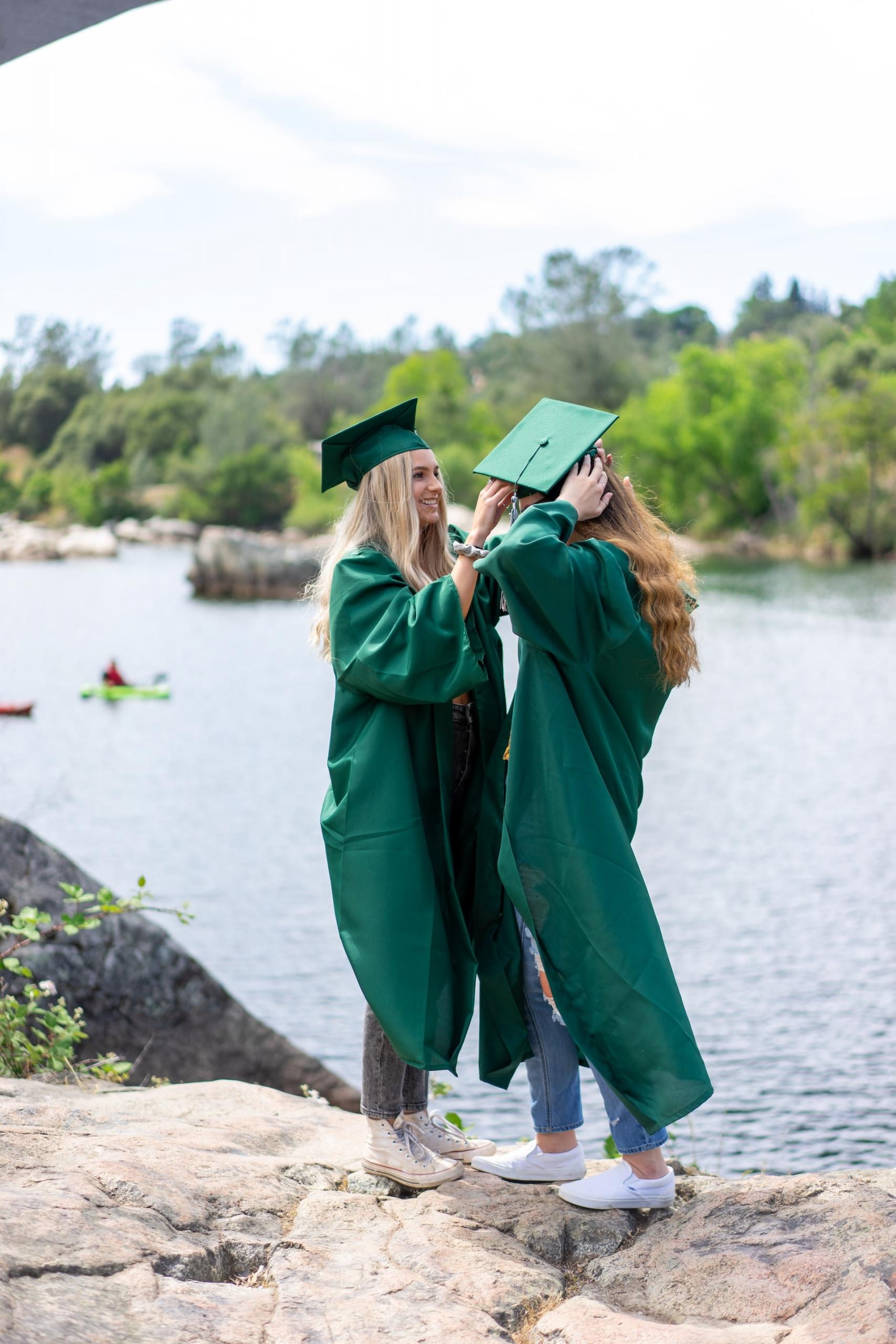 deux étudiantes en train de célébrer leur diplôme en tenue officielle