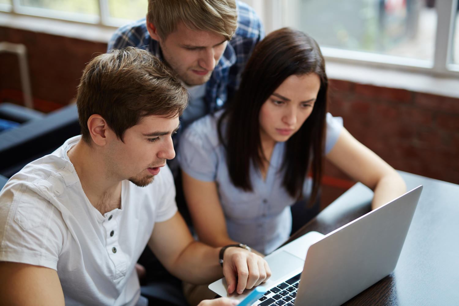 3 étudiants sont rassemblés autour d'un ordinateur. 