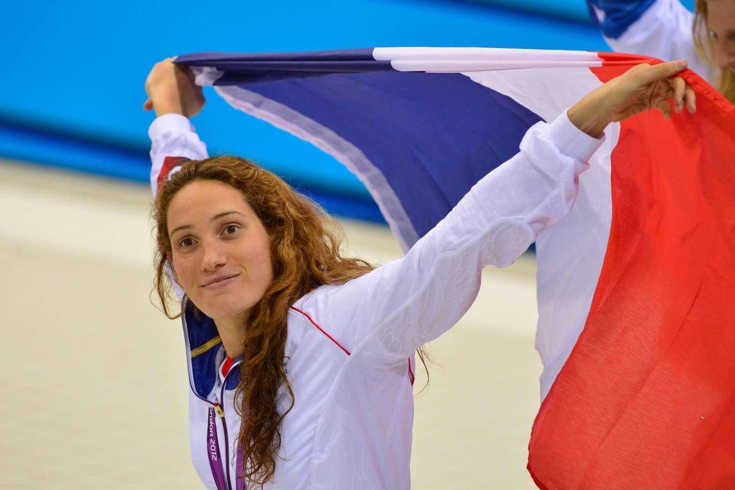 Camille Muffat en train de tenir le drapeau tricolore.