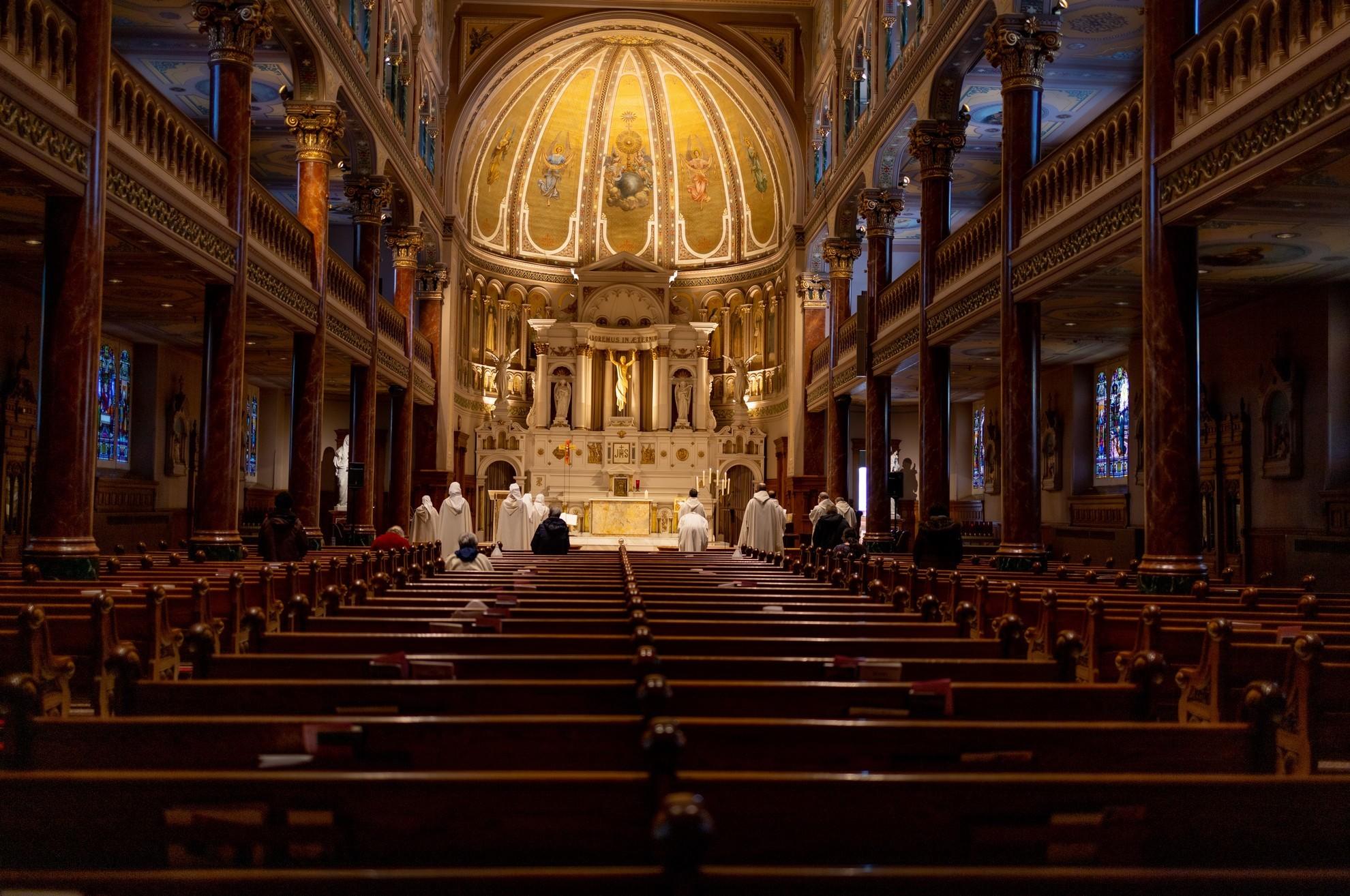 Une cérémonie religieuse dans une grande église baroque.