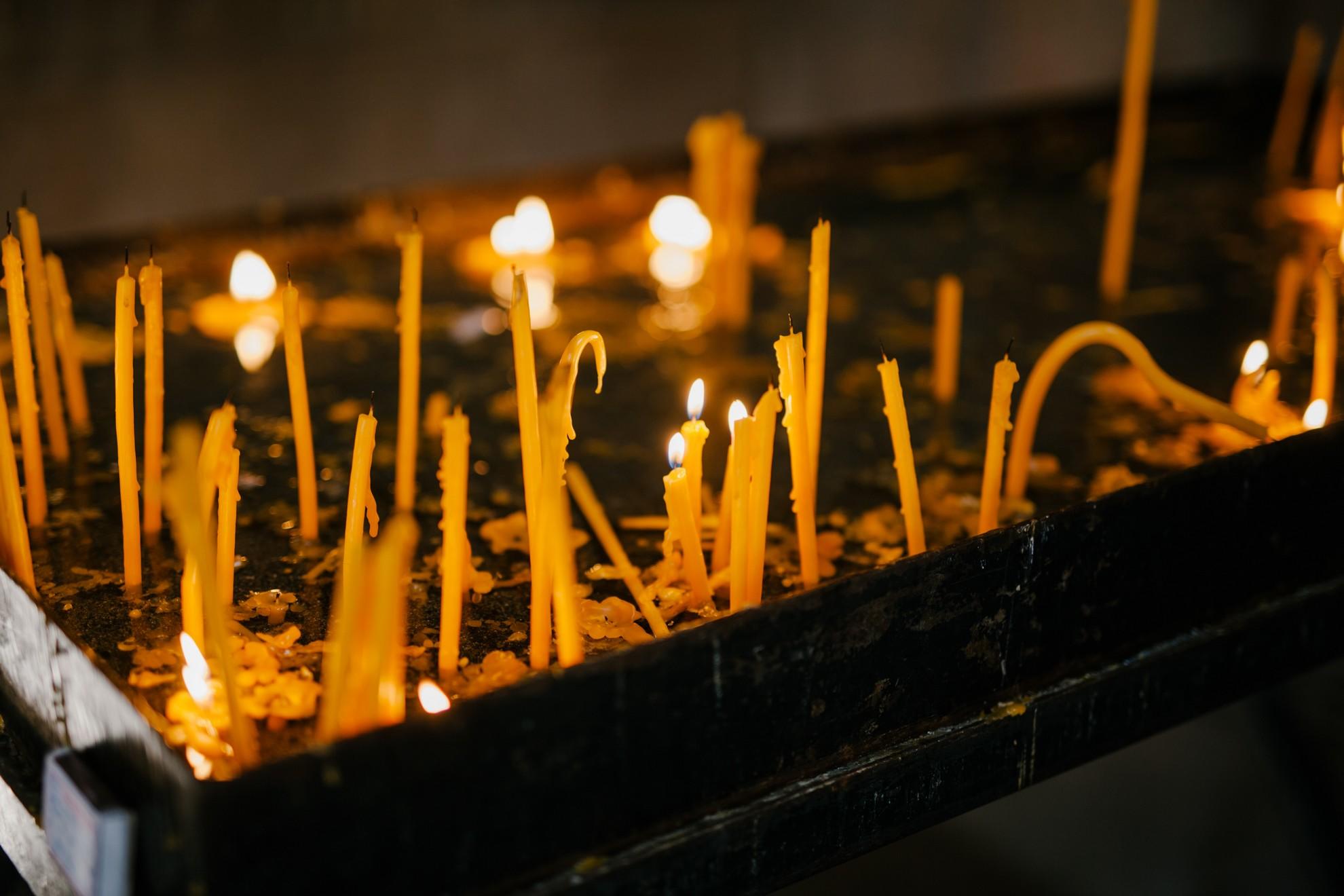 Des bougies qui fondent dans une chapelle.
