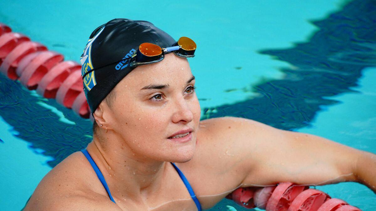 Mélanie Henique avec un bonnet de bain et des lunettes de natation dans une piscine.