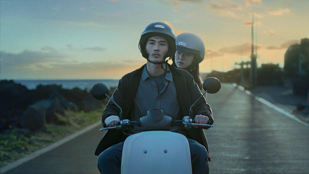 Un homme et une femme sont sur un scooter.