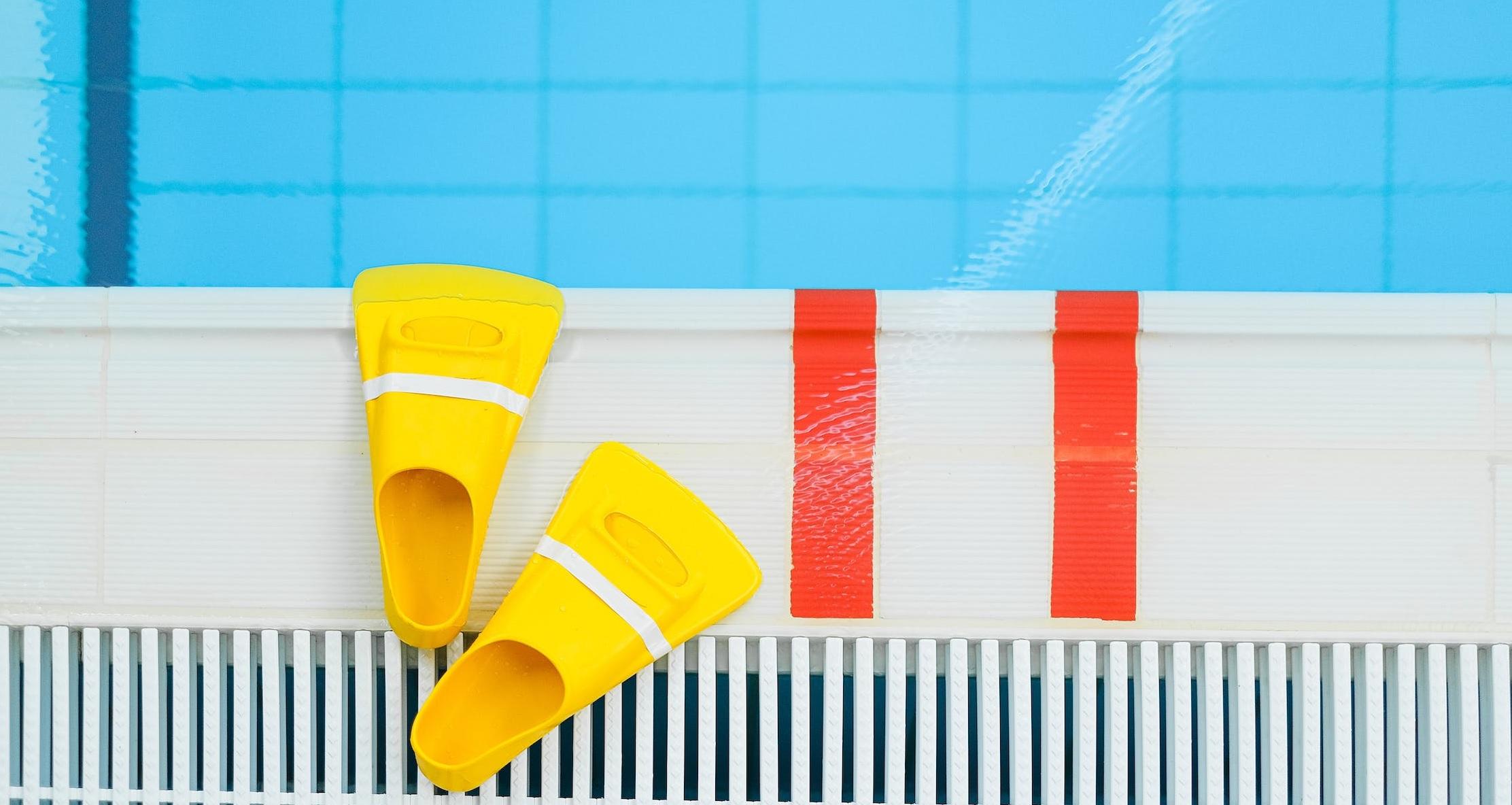 Des palmes sont posées au bord de la piscine.