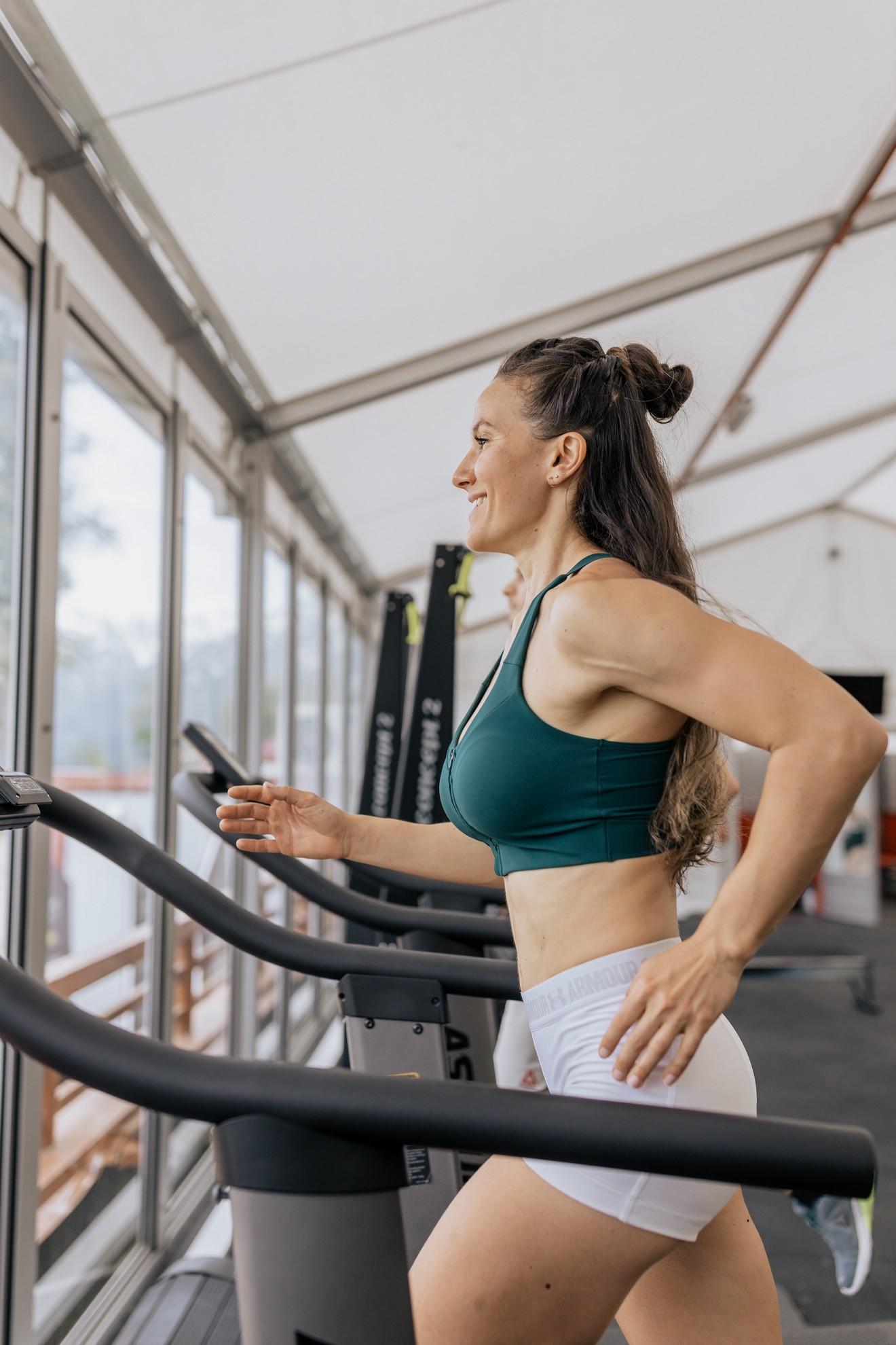 Une femme courant sur un tapis de course.