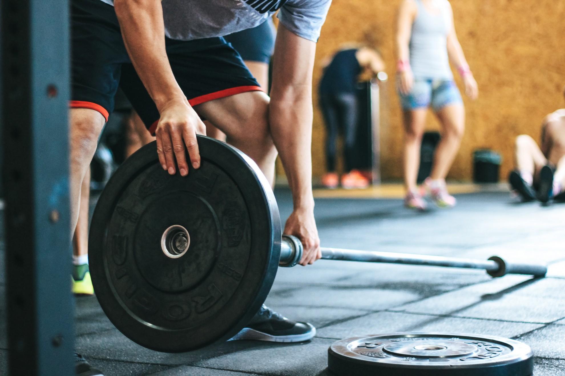 Un homme dans une salle de sport pratiquant la musculation.