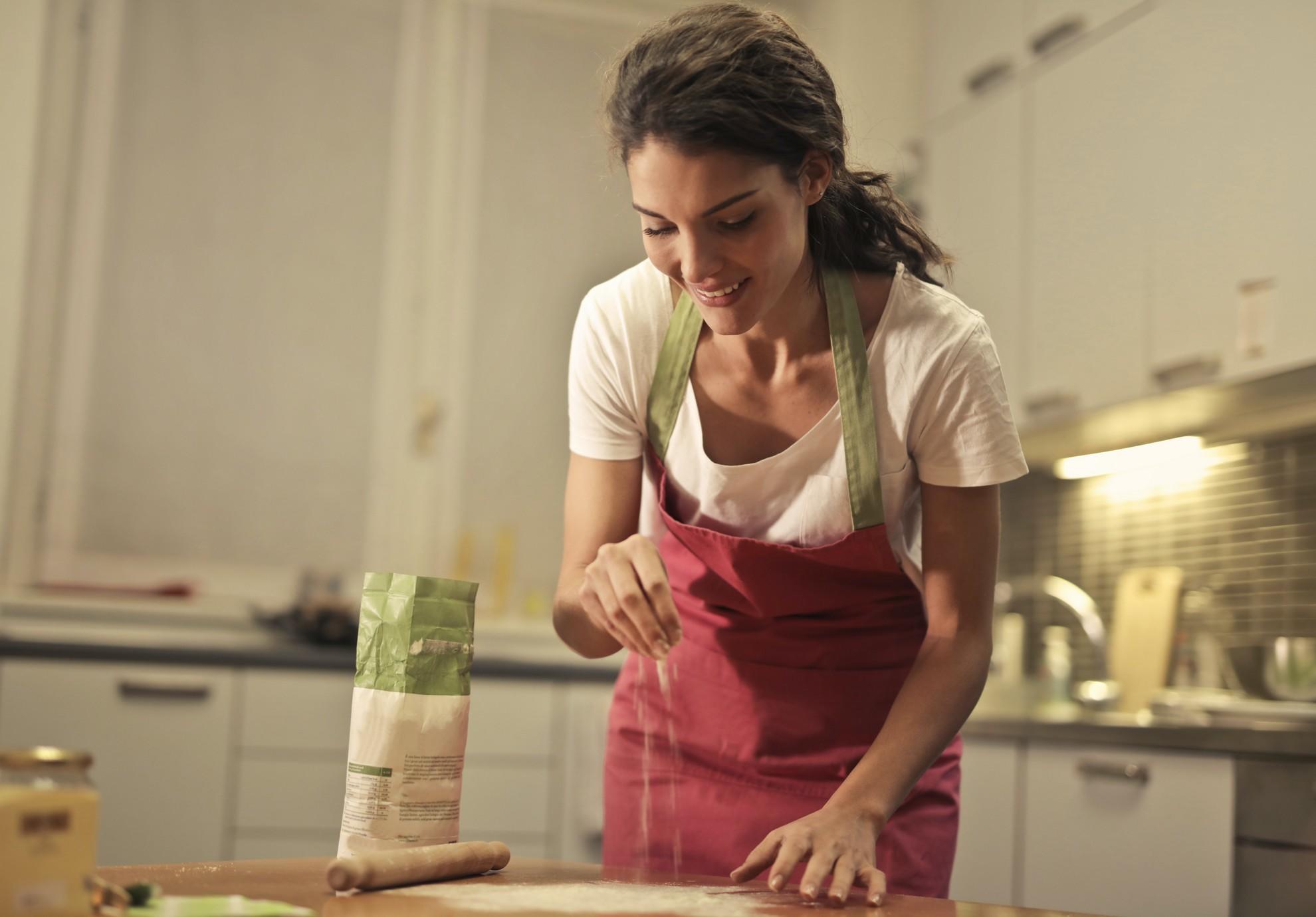 Une jeune femme en train de cuisiner.