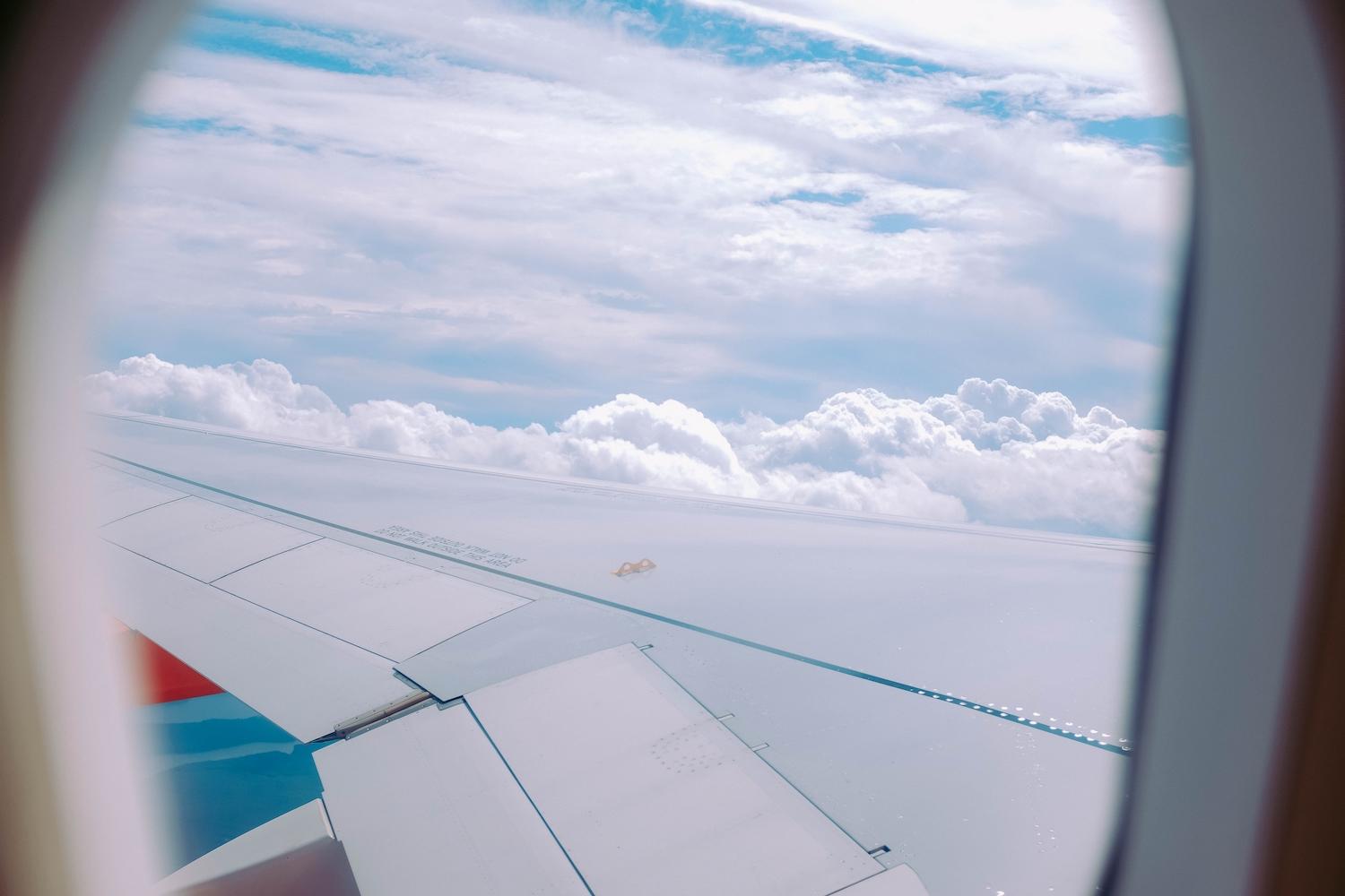 Vue sur les nuages depuis le hublot d'un avion.