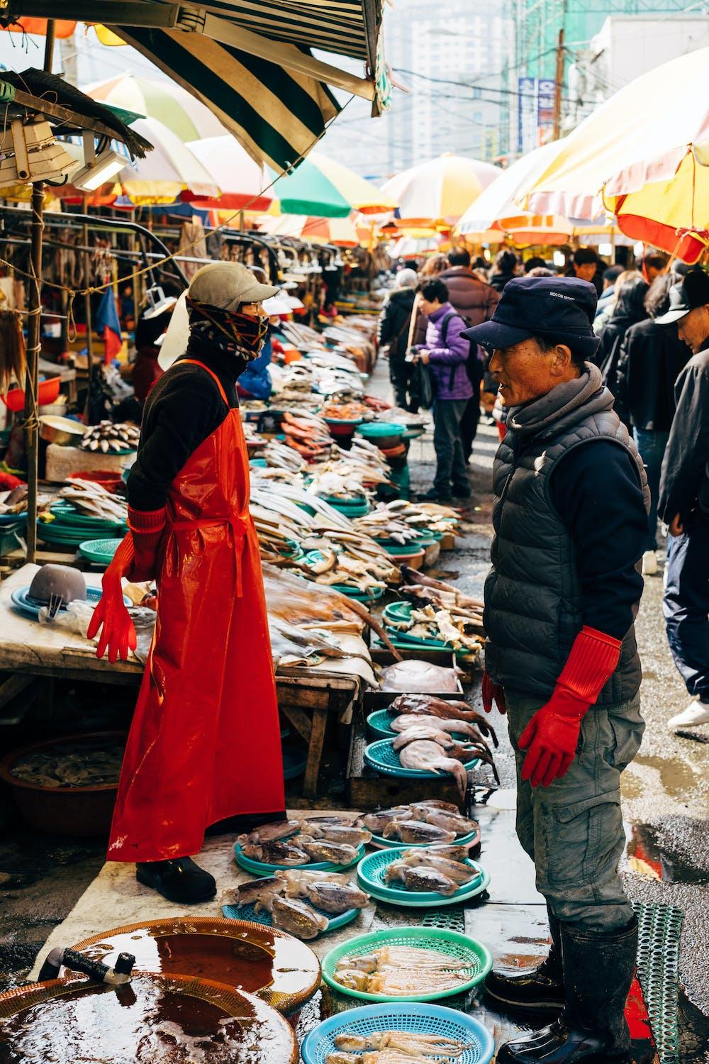Des personnes vendent leurs poissons au marché de Busan.