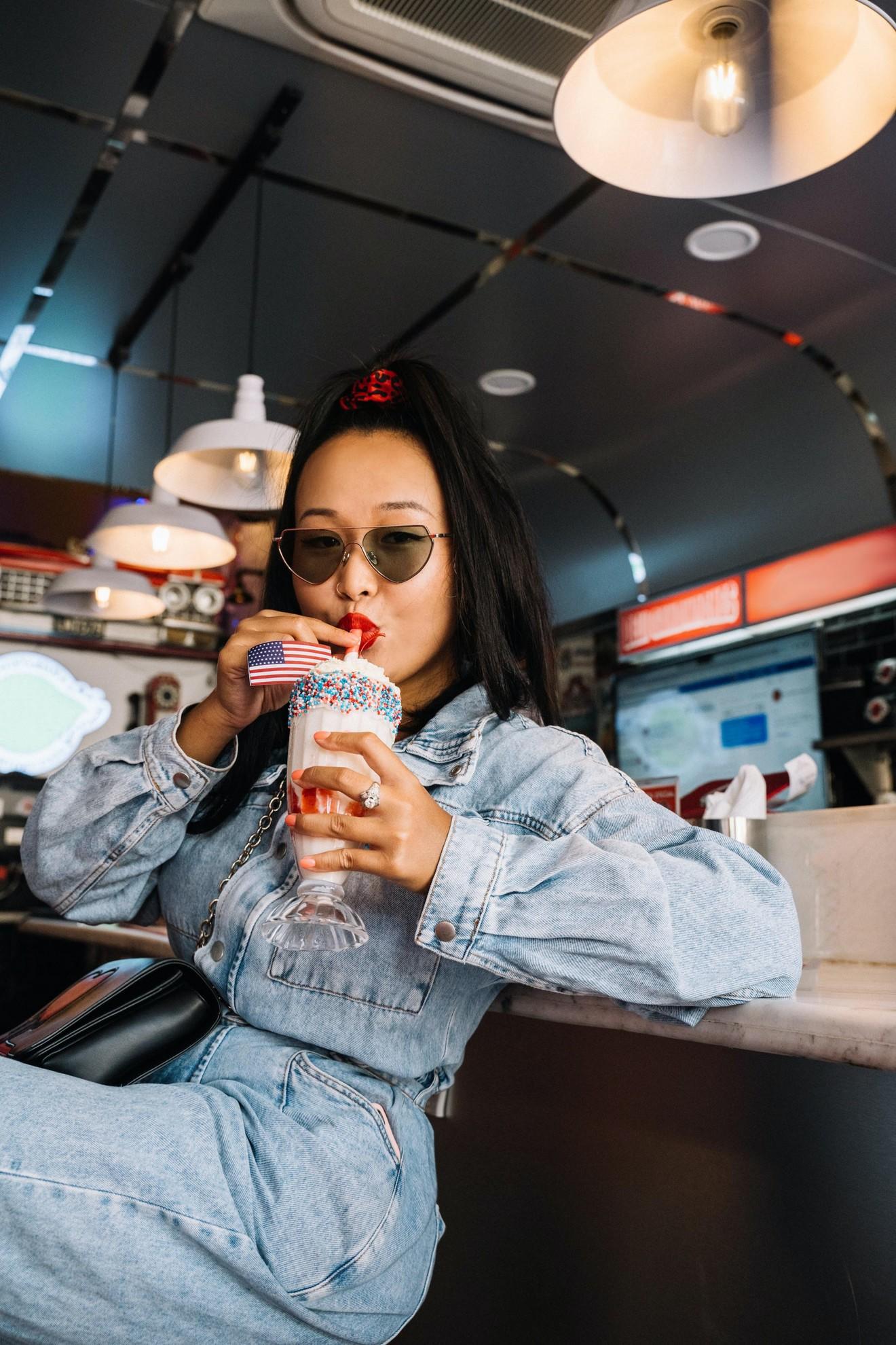 Une jeune fille en train de boire un milkshake.