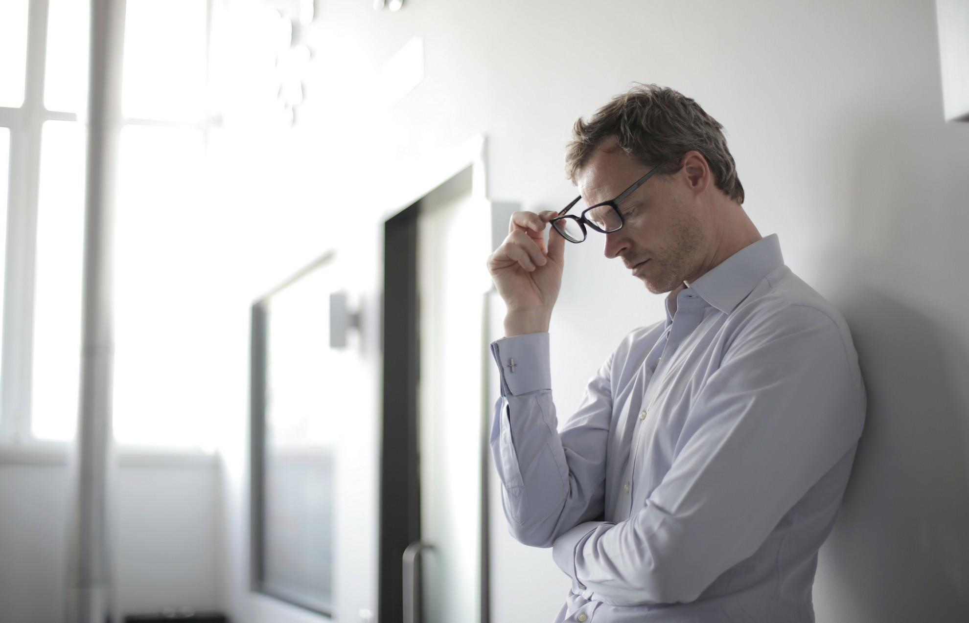 Un professeur en train de retirer ses lunettes de vue.