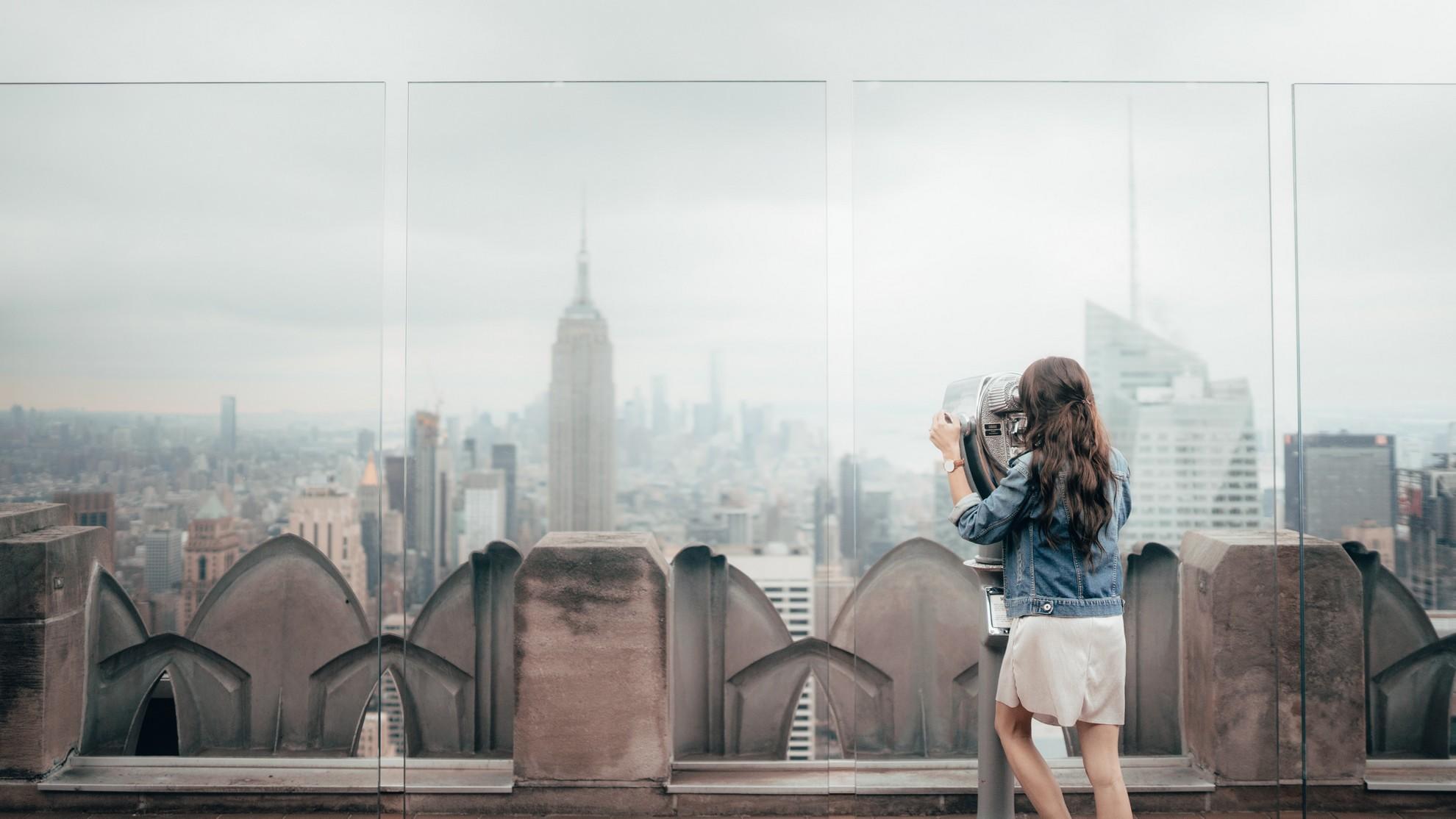 Une femme en train d'observer les buildings à New York.