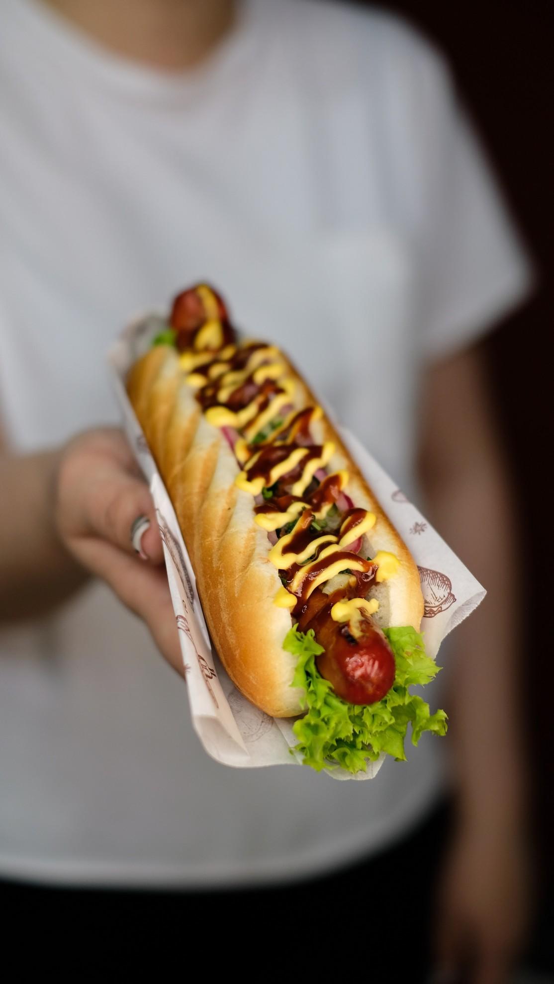 Une femme tenant un hot dog
