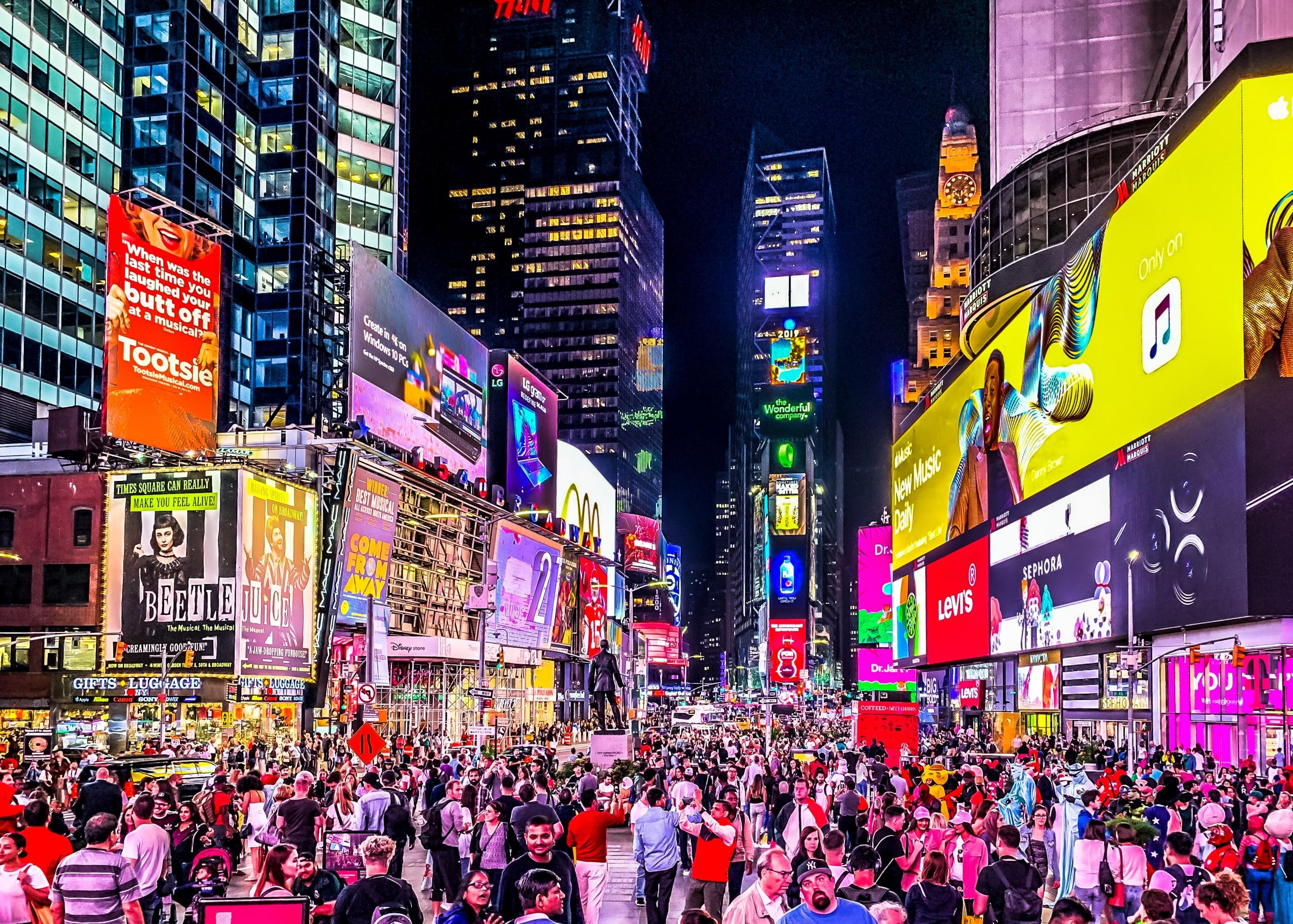 Times Square de nuit et sa foule.