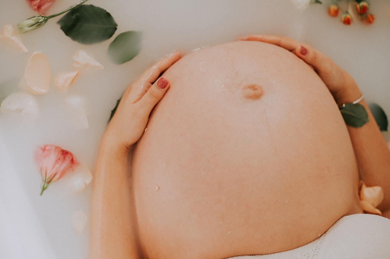 Le ventre d'une femme enceinte dans une baignoire. 