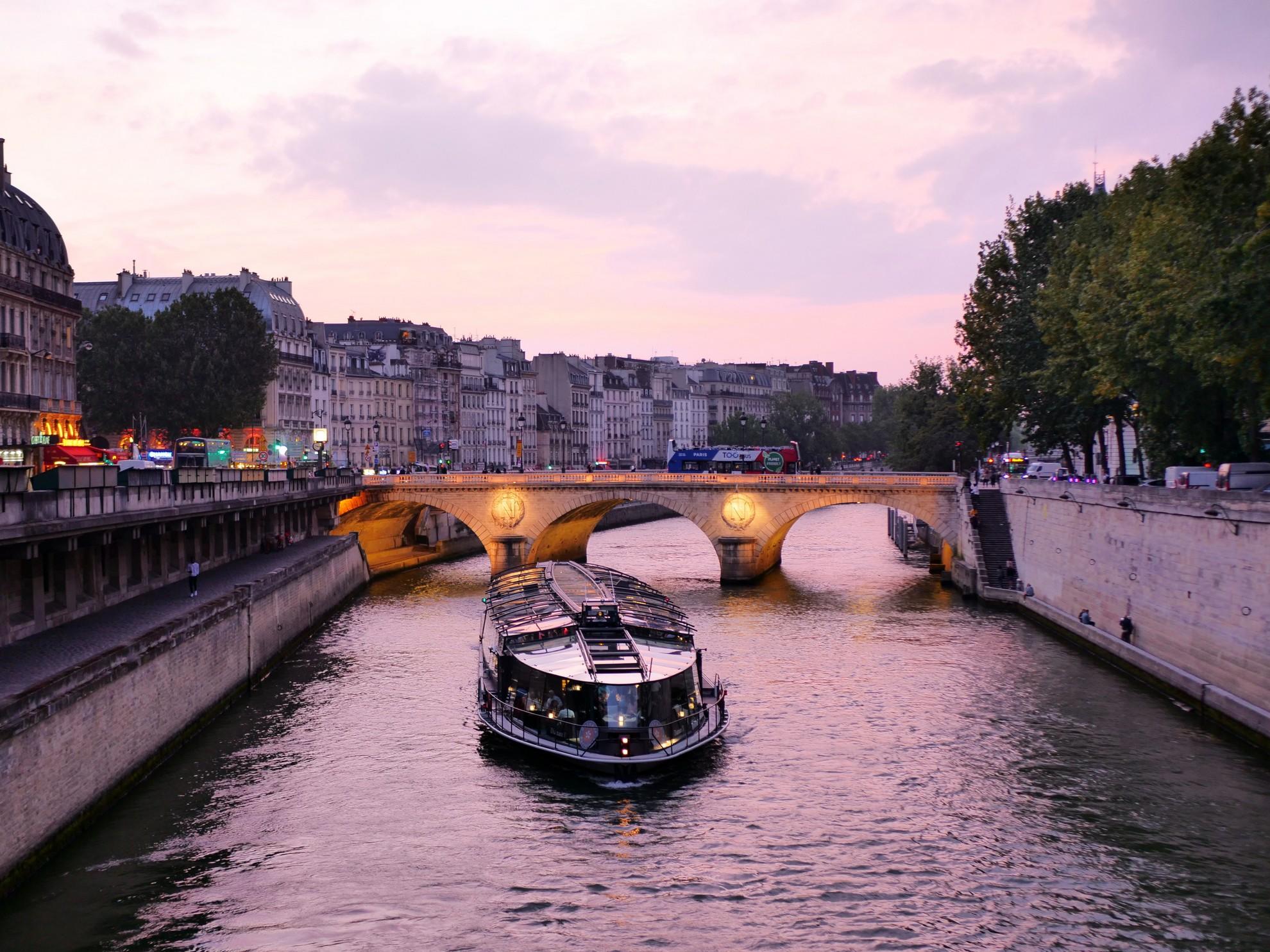 Un bateau mouche sur la Seine en soirée.