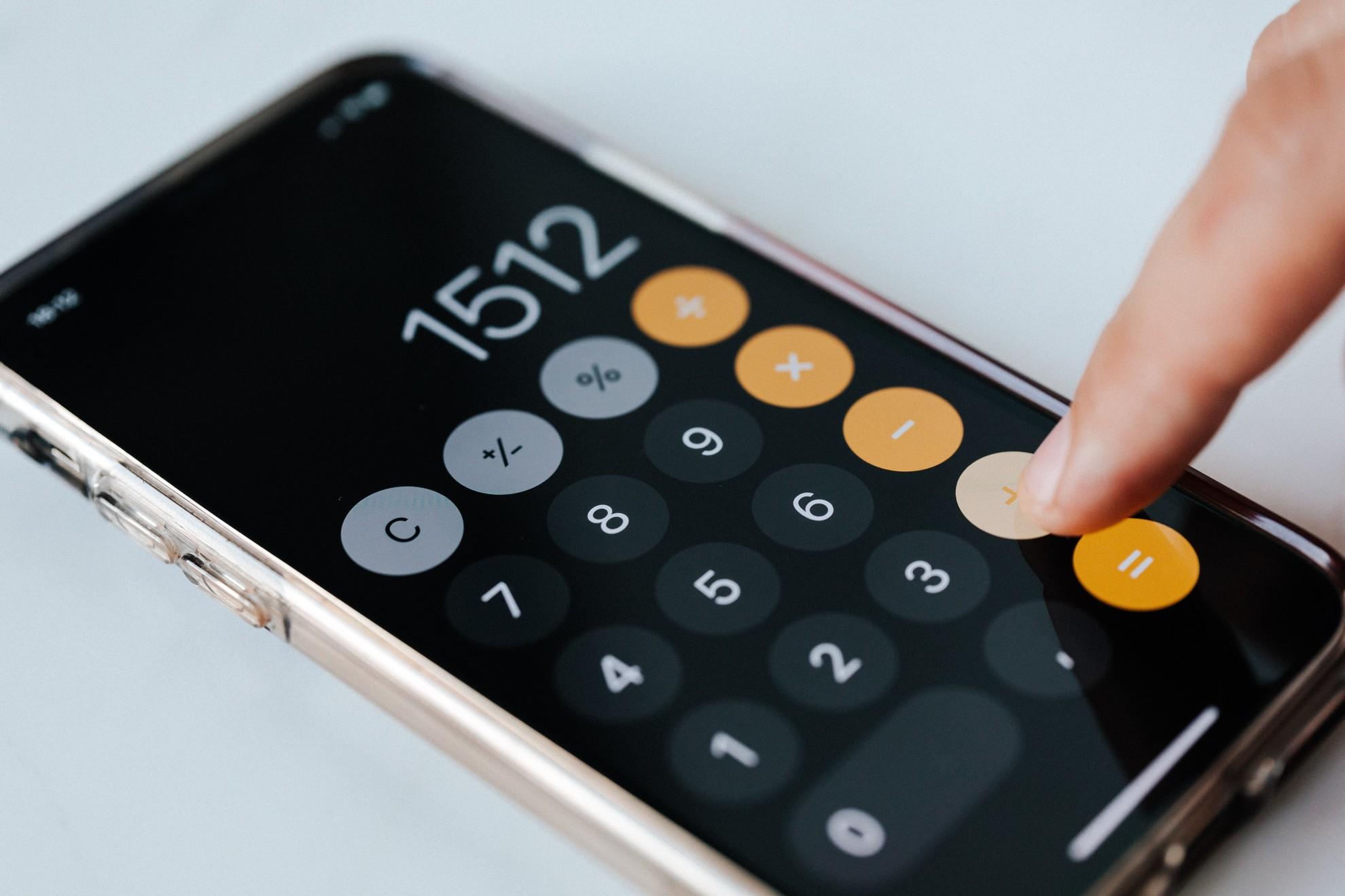 Une personne en train de faire des calculs avec son téléphone.