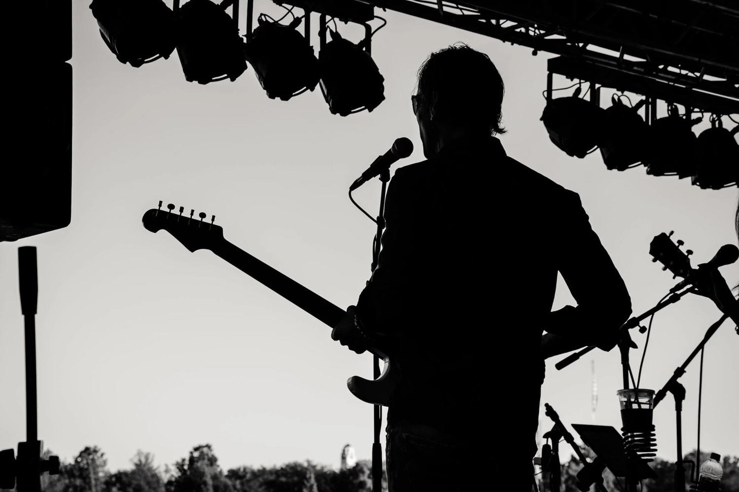 Un musicien joue de la guitare sur scène.