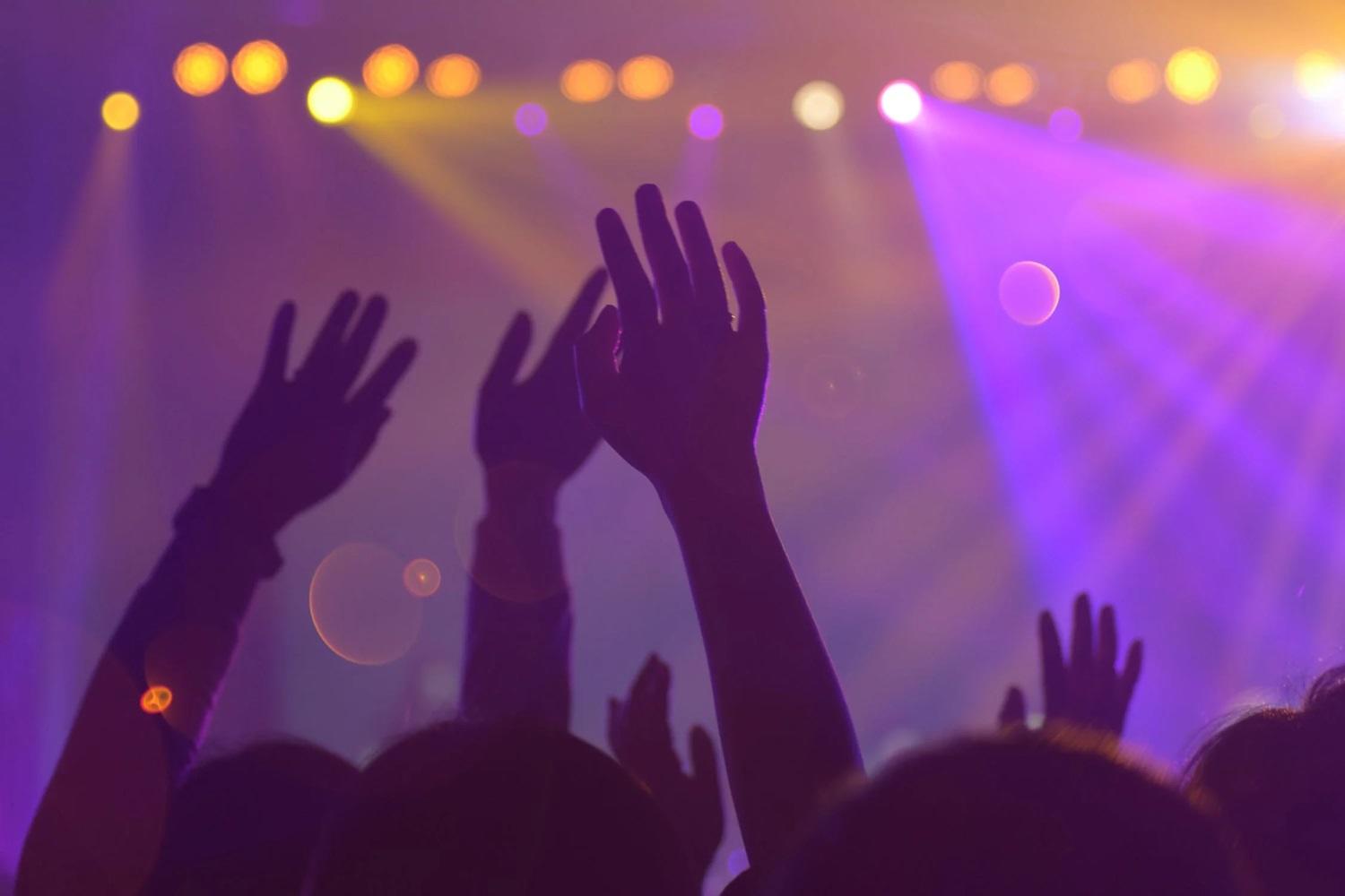 Des mains se lèvent lors d'un concert de musique.