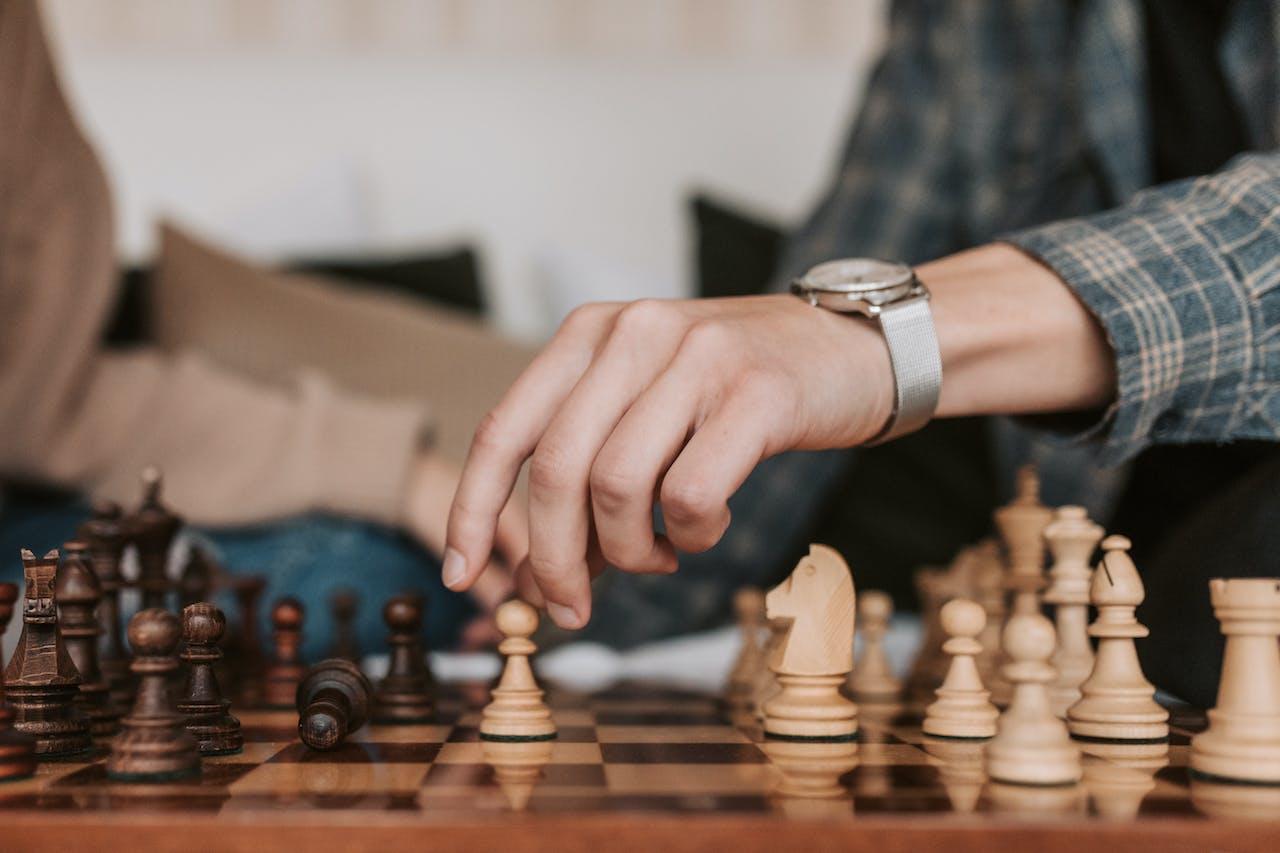 Deux personnes jouent aux échecs, on ne voit que leurs mains.