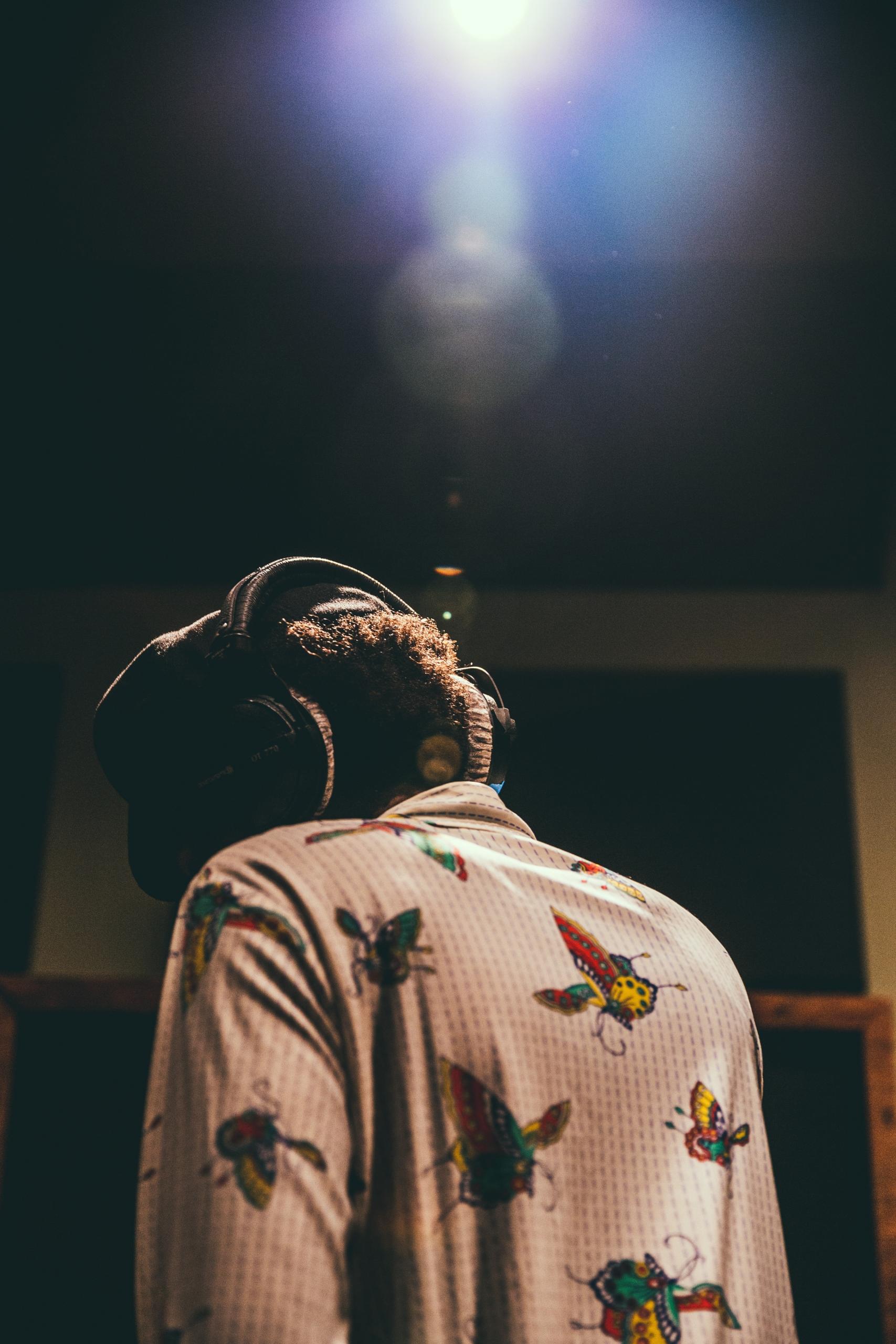 Un auditeur écoute de la musique de dos avec un casque.