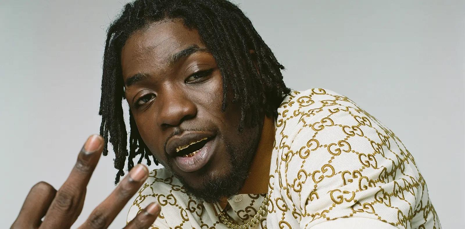 Le rappeur Gazo en gros plan avec la main en avant.