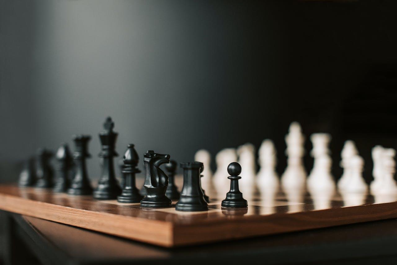 Plateau d'échecs avec les pièces noires et blanches placées pour débuter.