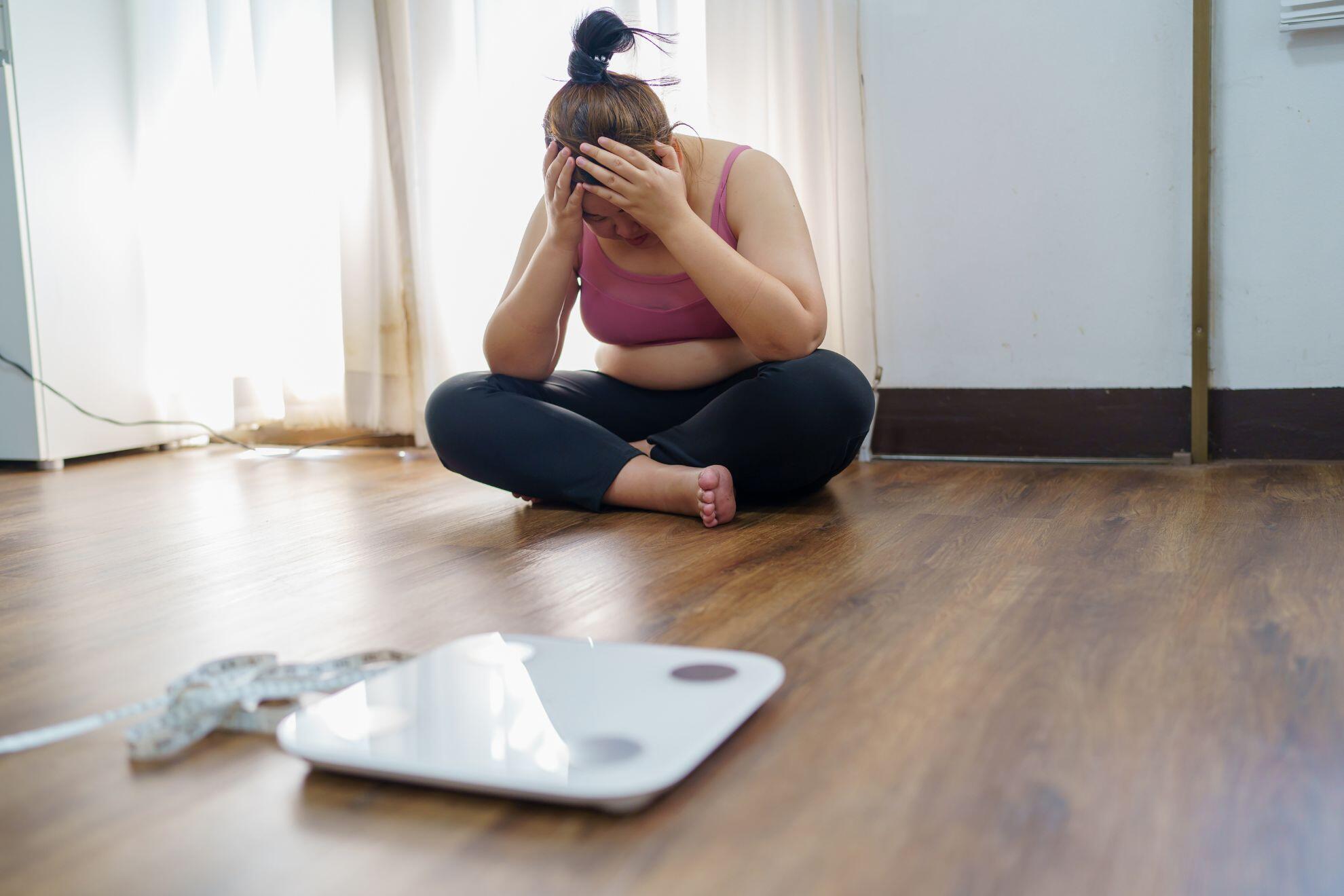 Une femme triste devant la balance.