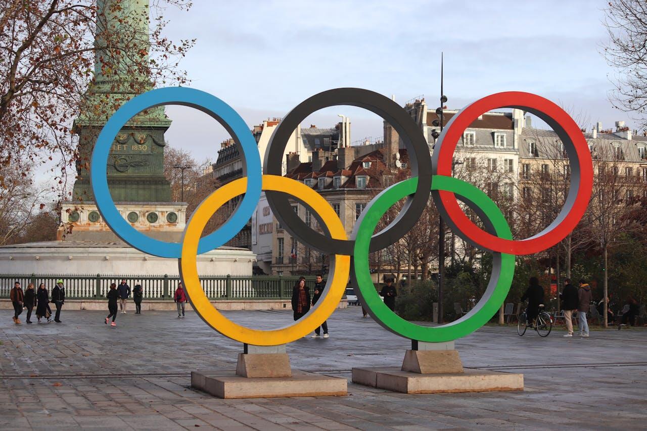 Anneaux olympiques sur une place parisienne.