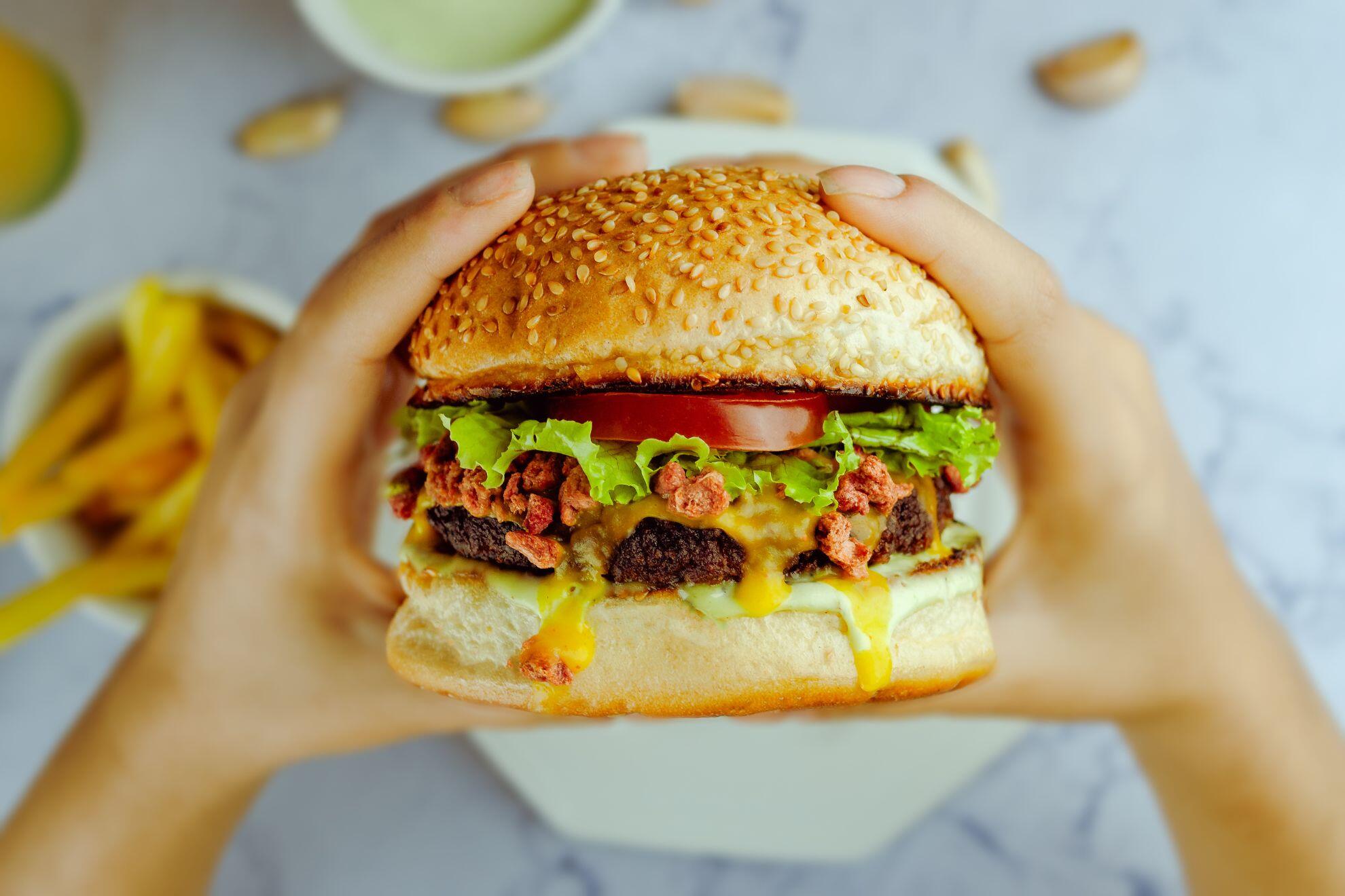 Une personne qui va manger un hamburger.