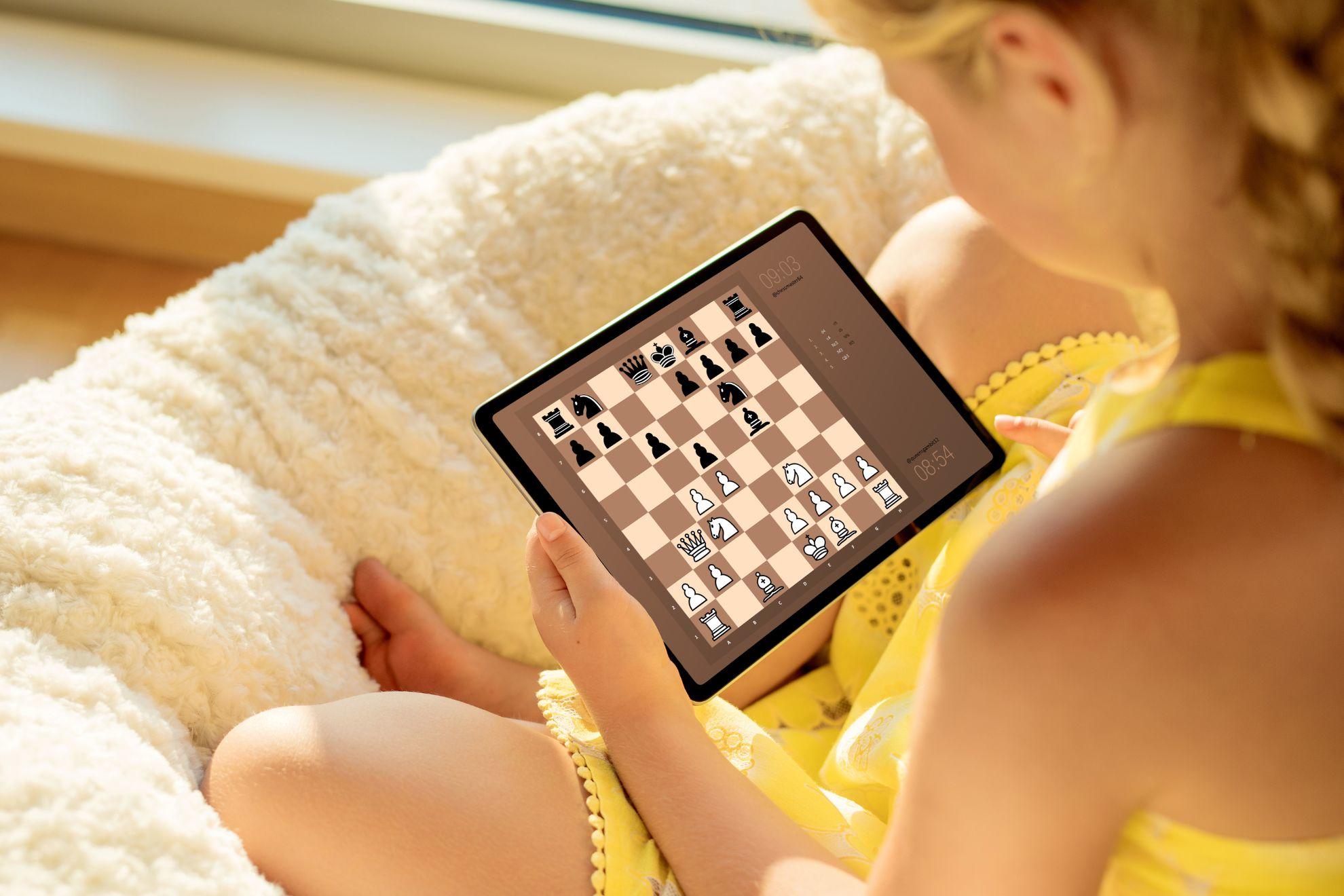 Une fillette en train de jouer aux échecs sur sa tablette.
