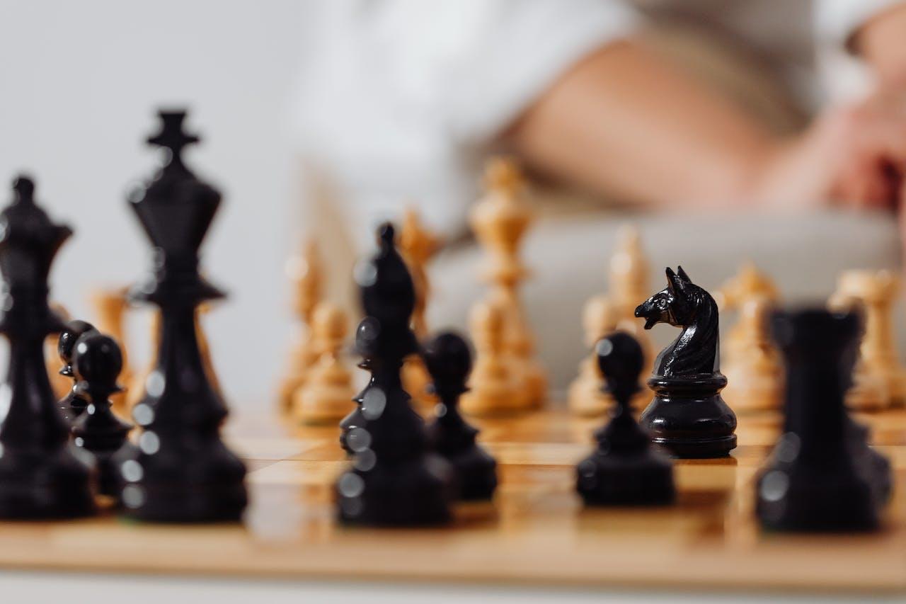 Gros plan sur un plateau d'échecs avec les pièces noires et blanches.