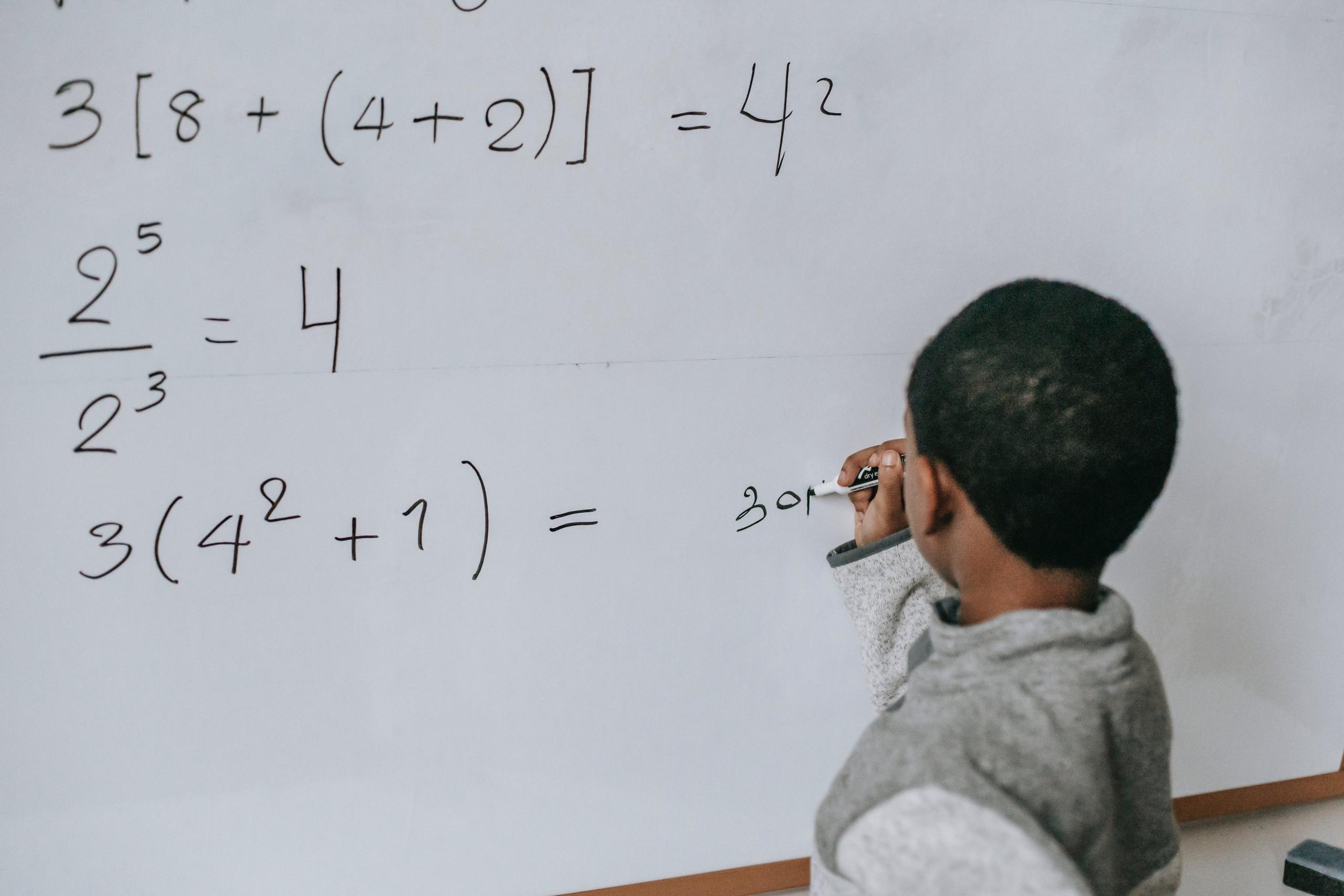 Un jeune garçon en train de résoudre un problème de mathématiques.