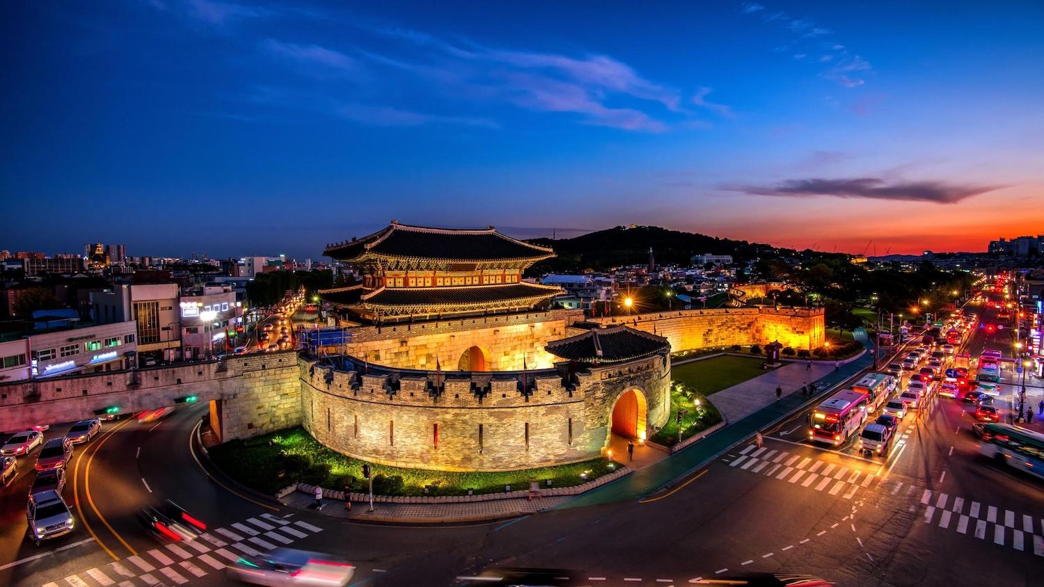 Vue de nuit sur les fortifications de Suwon éclairées.