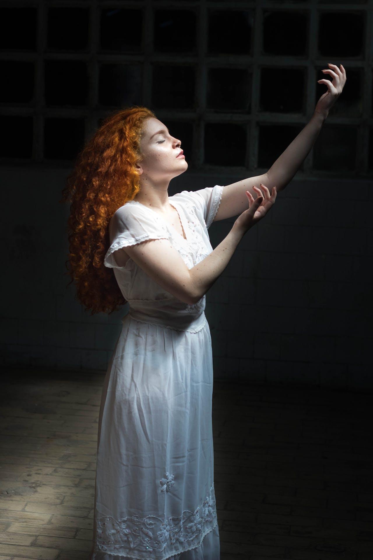 Jeune femme rousse sur une scène de théâtre qui joue une pièce.