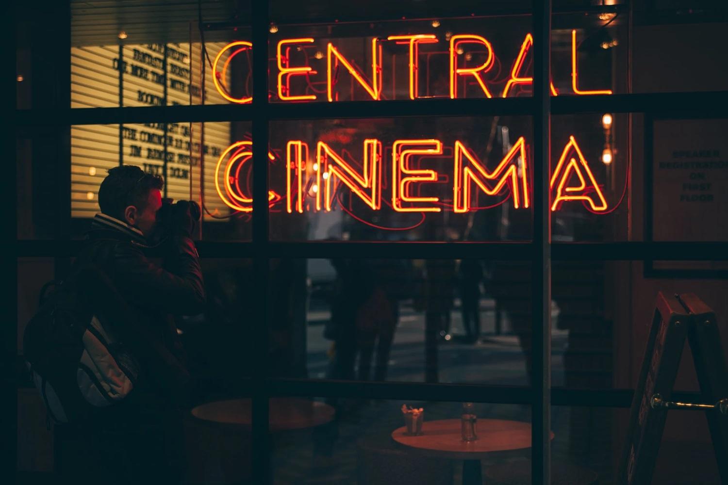 Une personne se trouve devant un cinéma. 