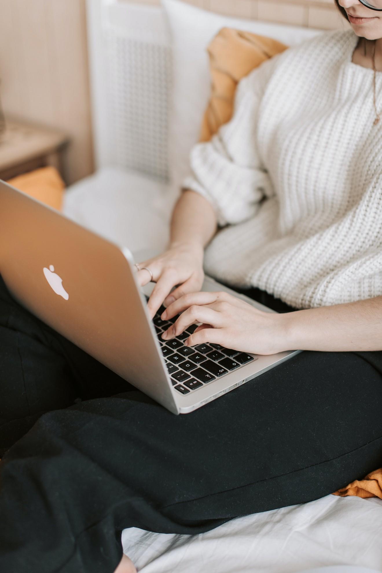 Une femme en train de travailler sur son MacBook.