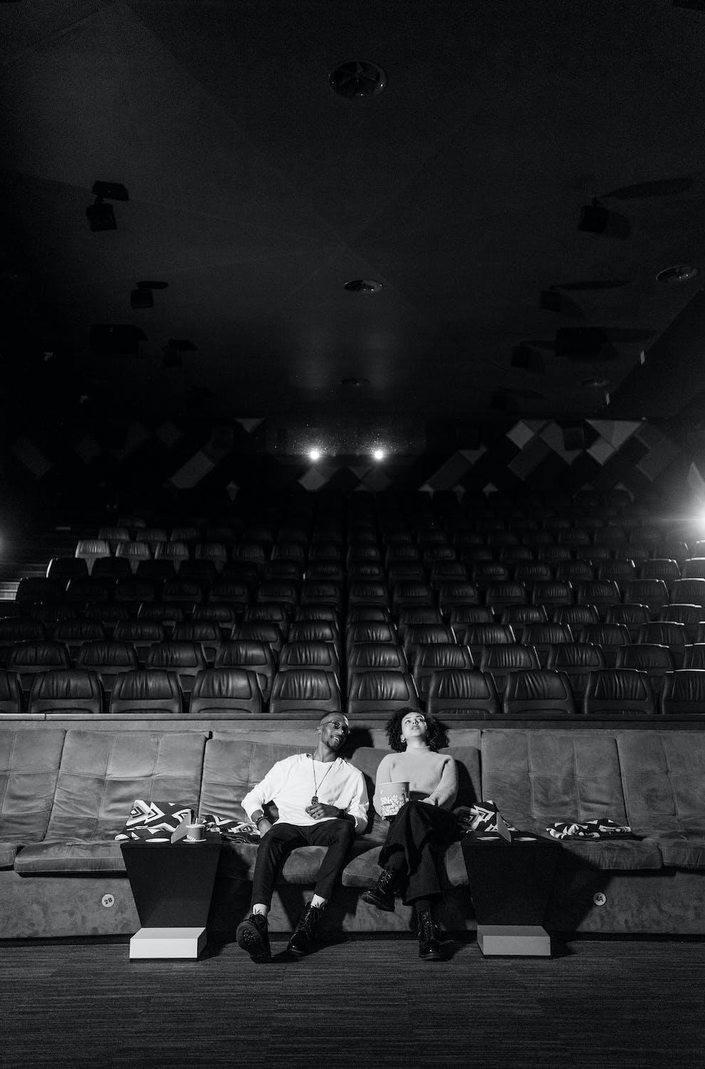 Deux personnes se trouvent dans une salle de cinéma.