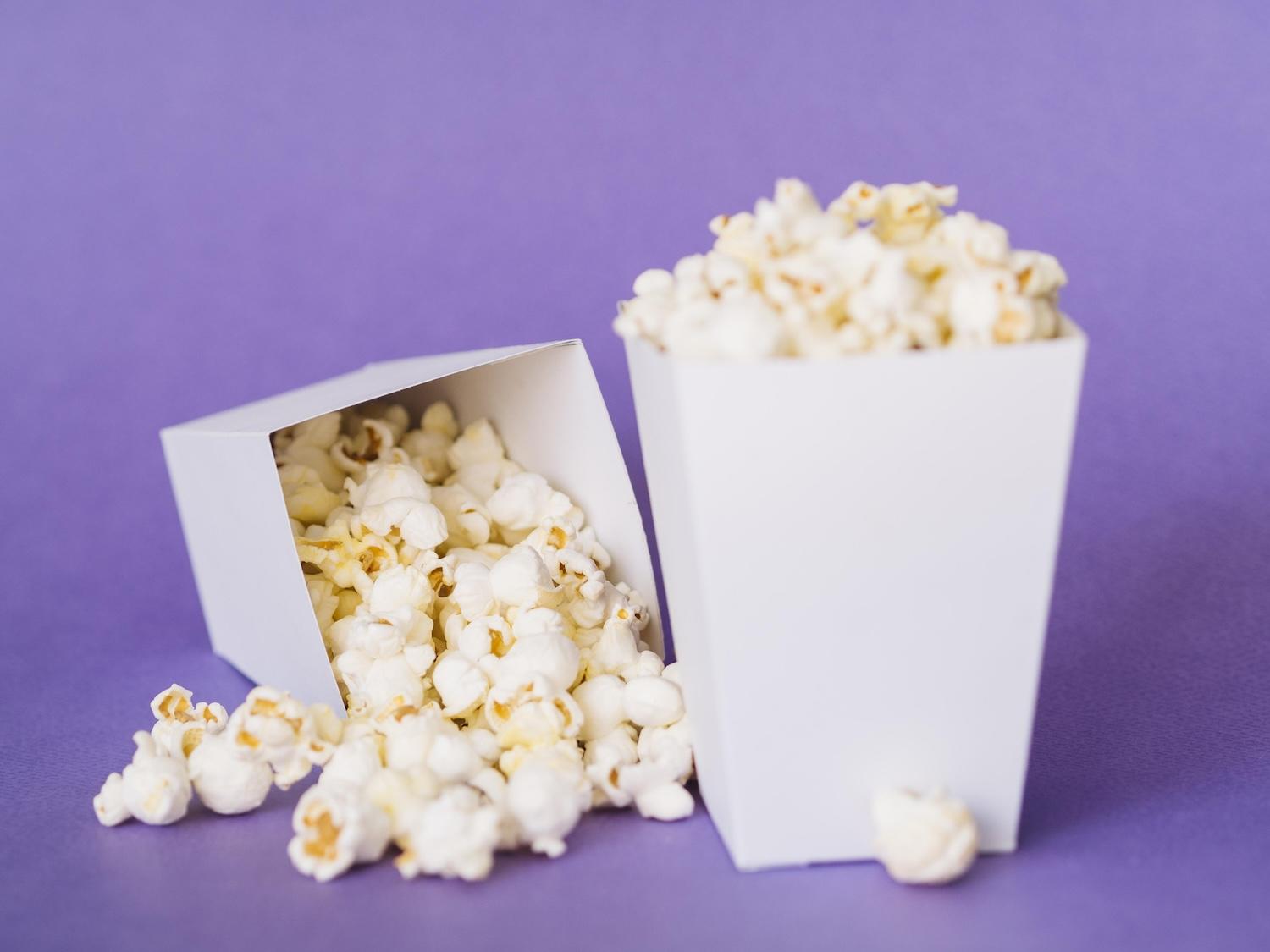 2 pots en carton avec des pop-corn à l'intérieur.