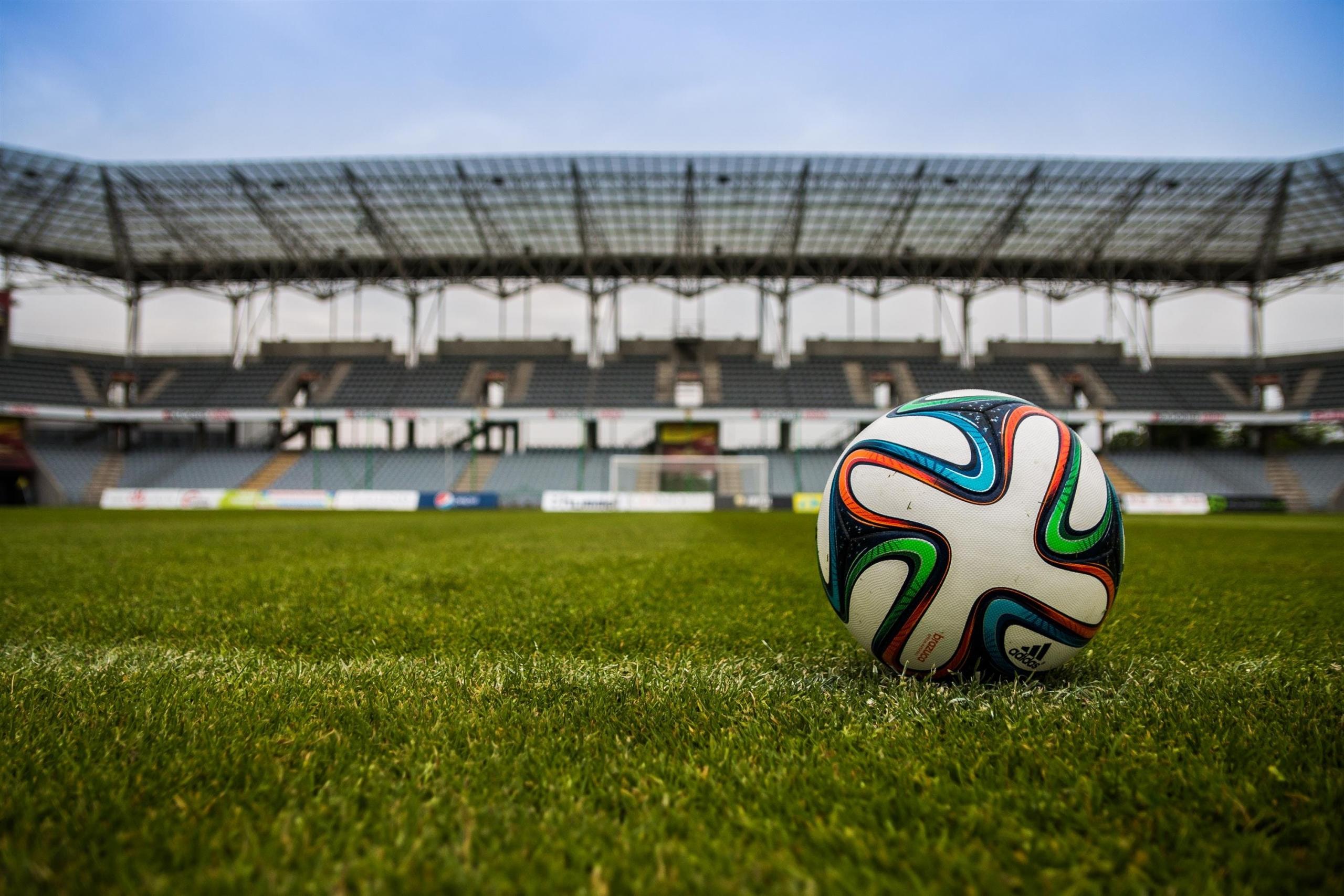 Un ballon sur la pelouse d'un terrain de foot.