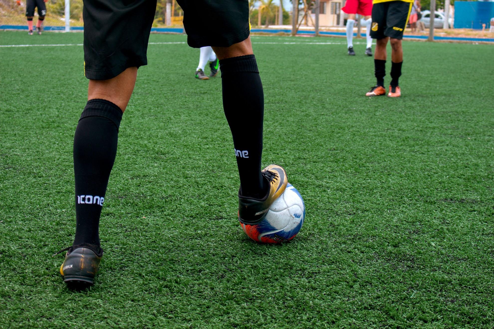 Un homme qui va tirer dans un ballon de football lors d'un match.
