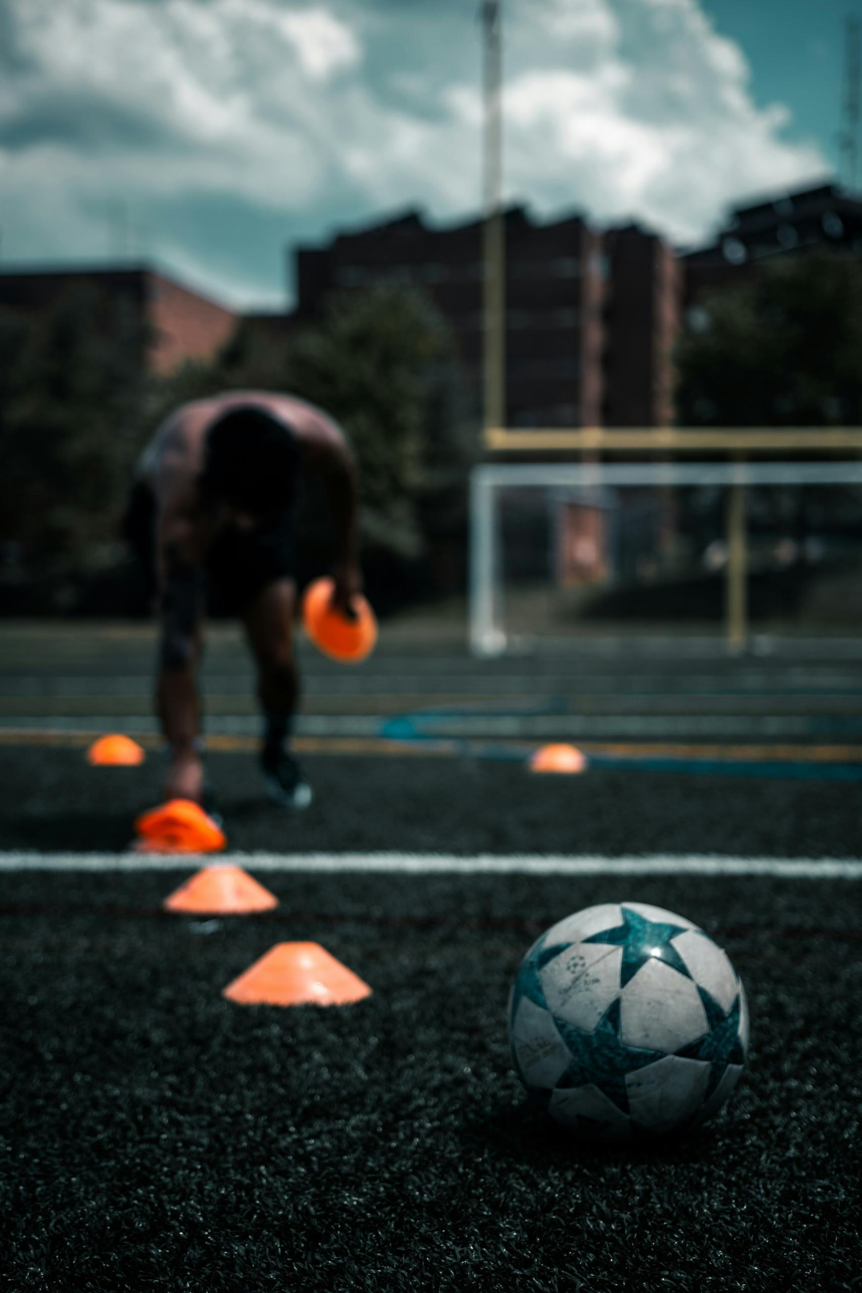 Un entraineur de foot en train de préparer un exercice.
