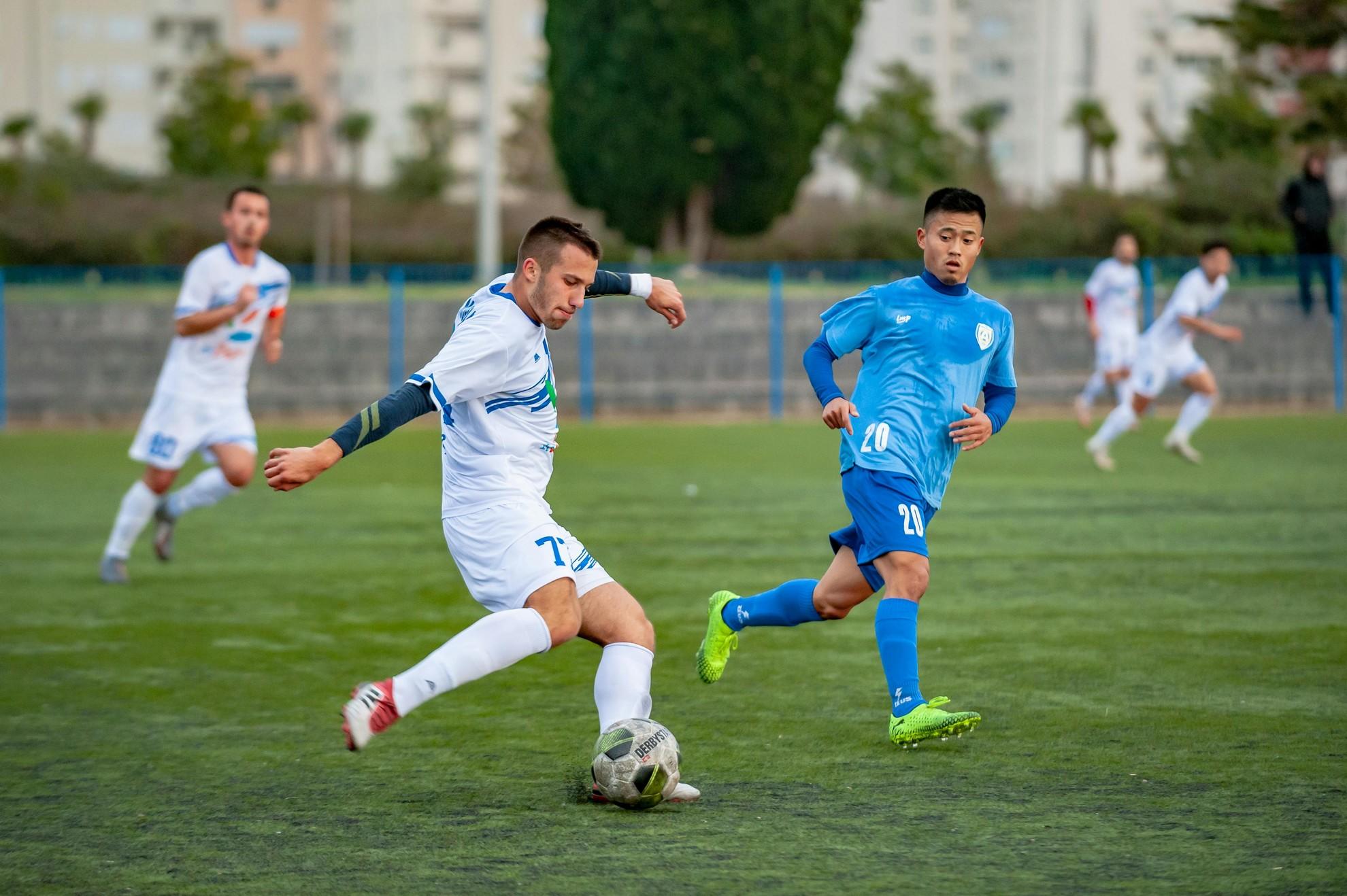 Deux hommes en train de jouer un match de football.