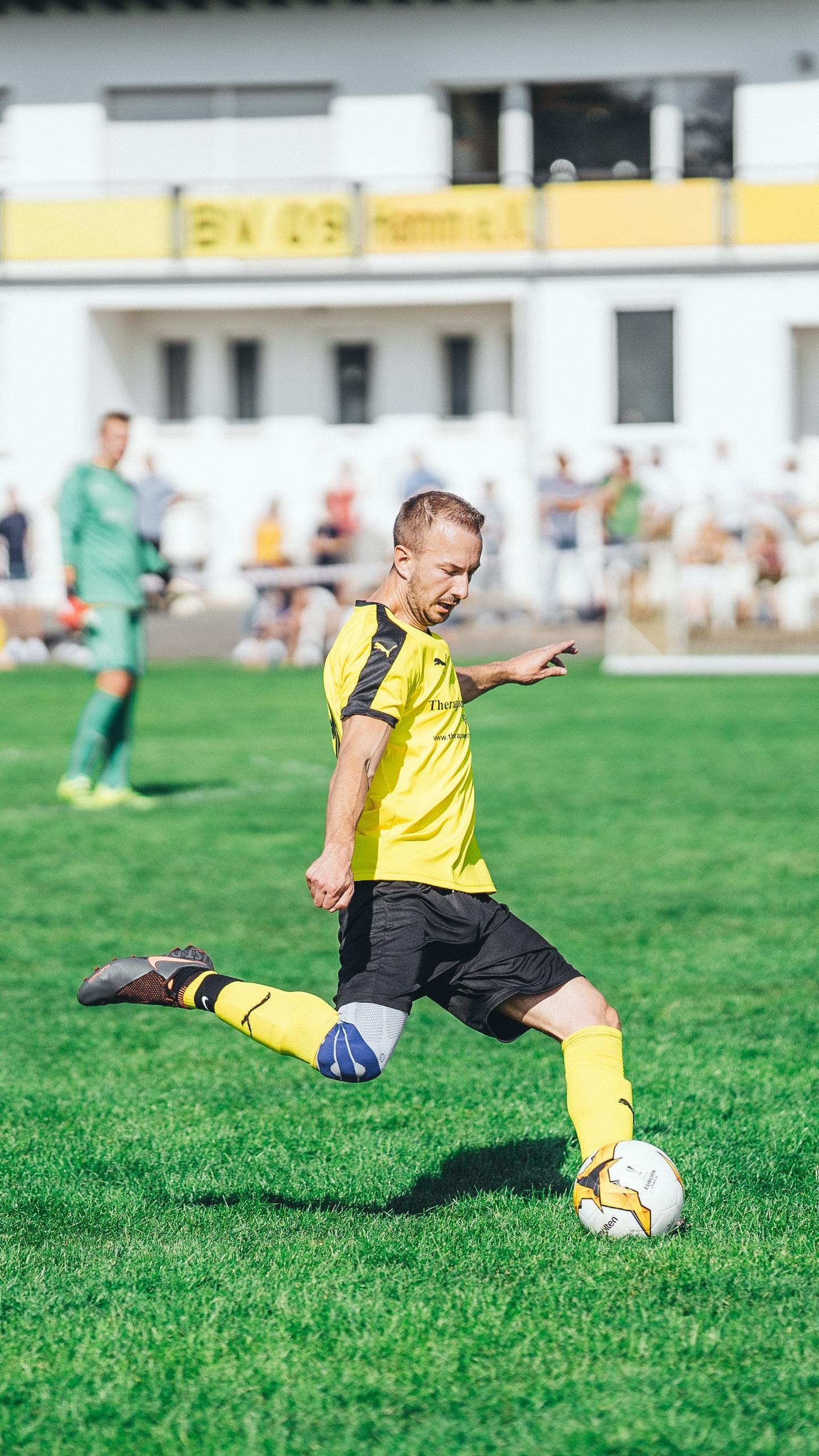 Un joueur s'entraîne au foot sur un terrain.