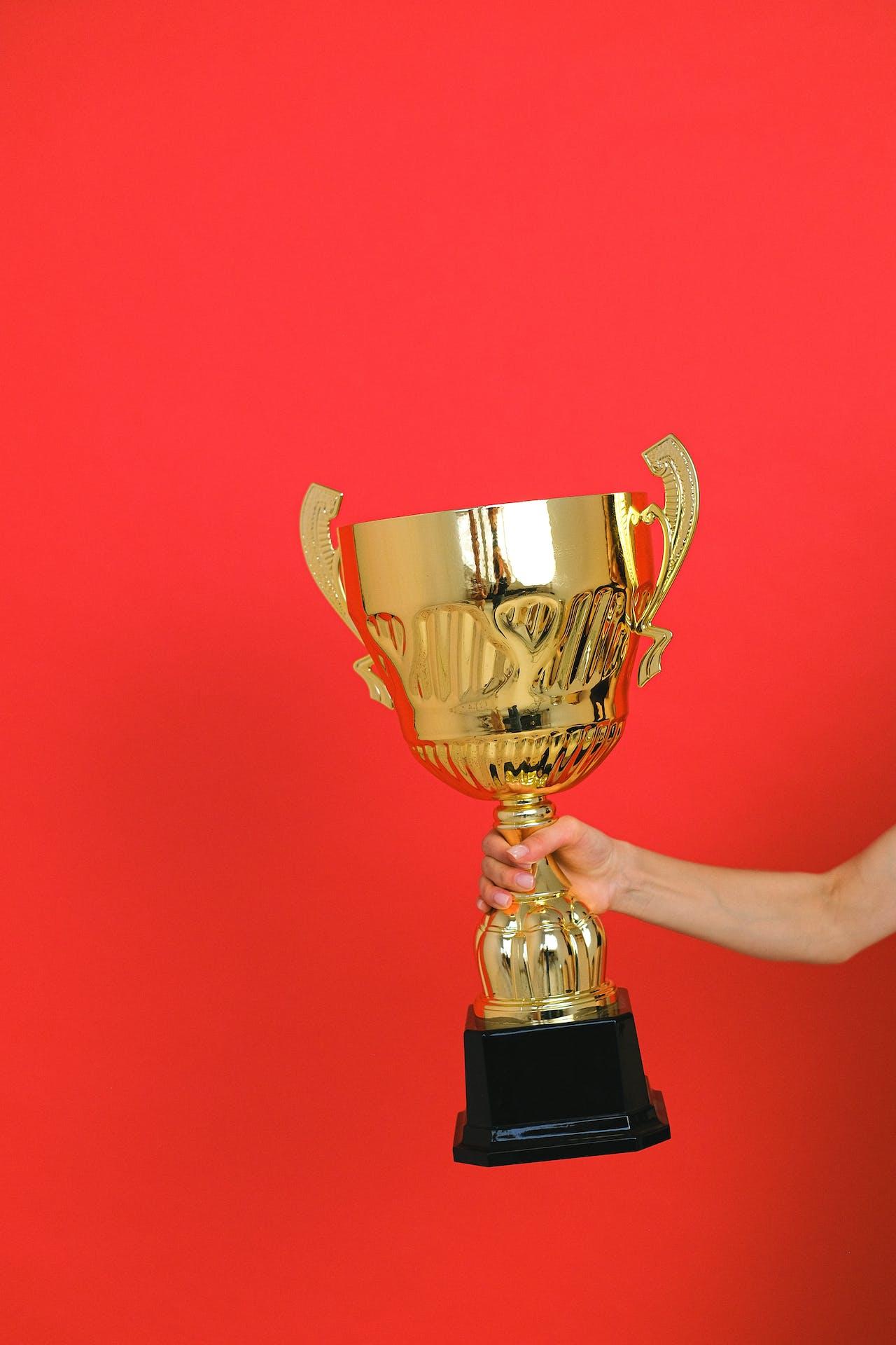 Coupe brandie par un bras droit sur fond rouge. 