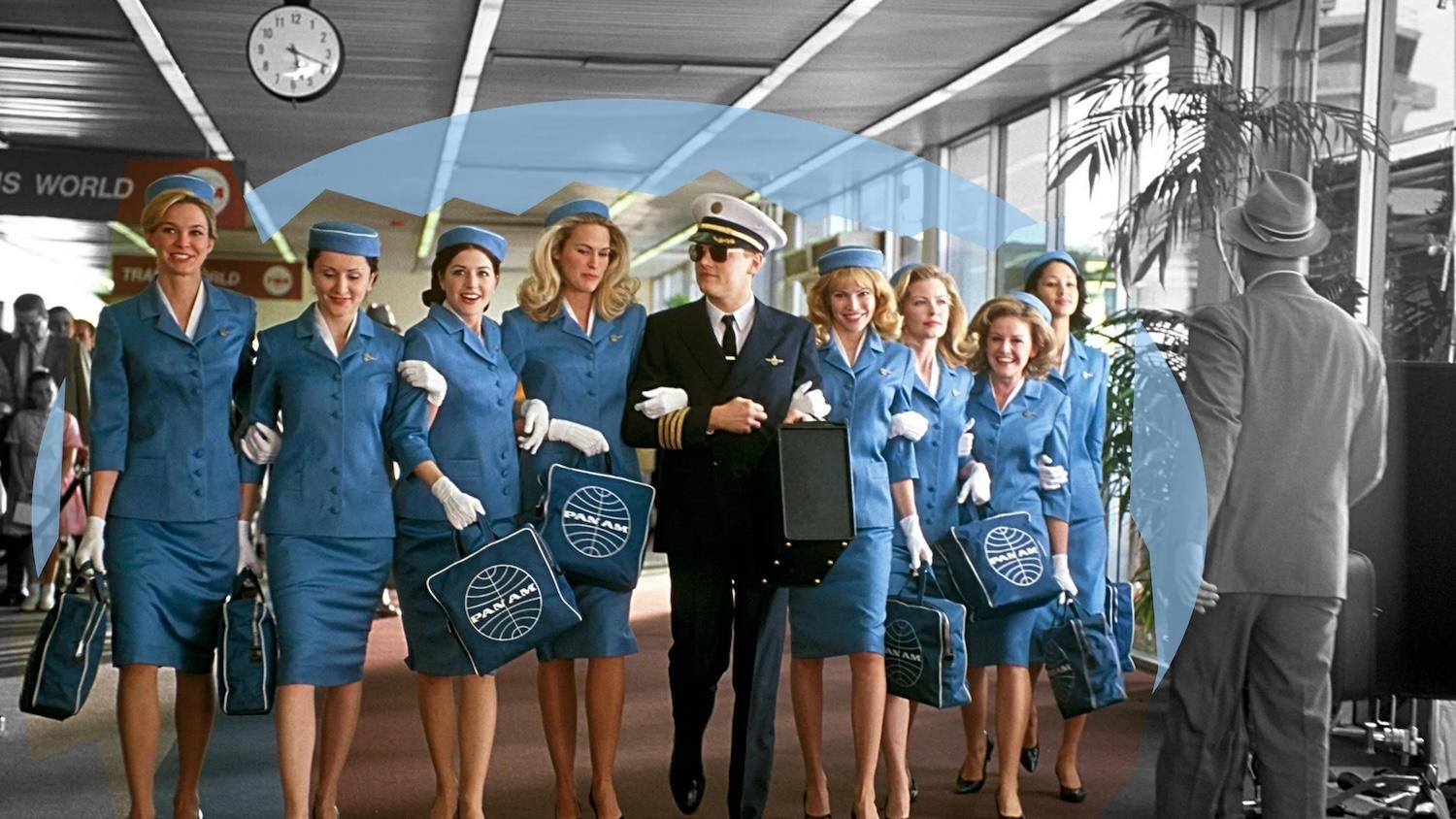 Un commandant de bord est entouré de nombreuses hôtesses de l'air. 
