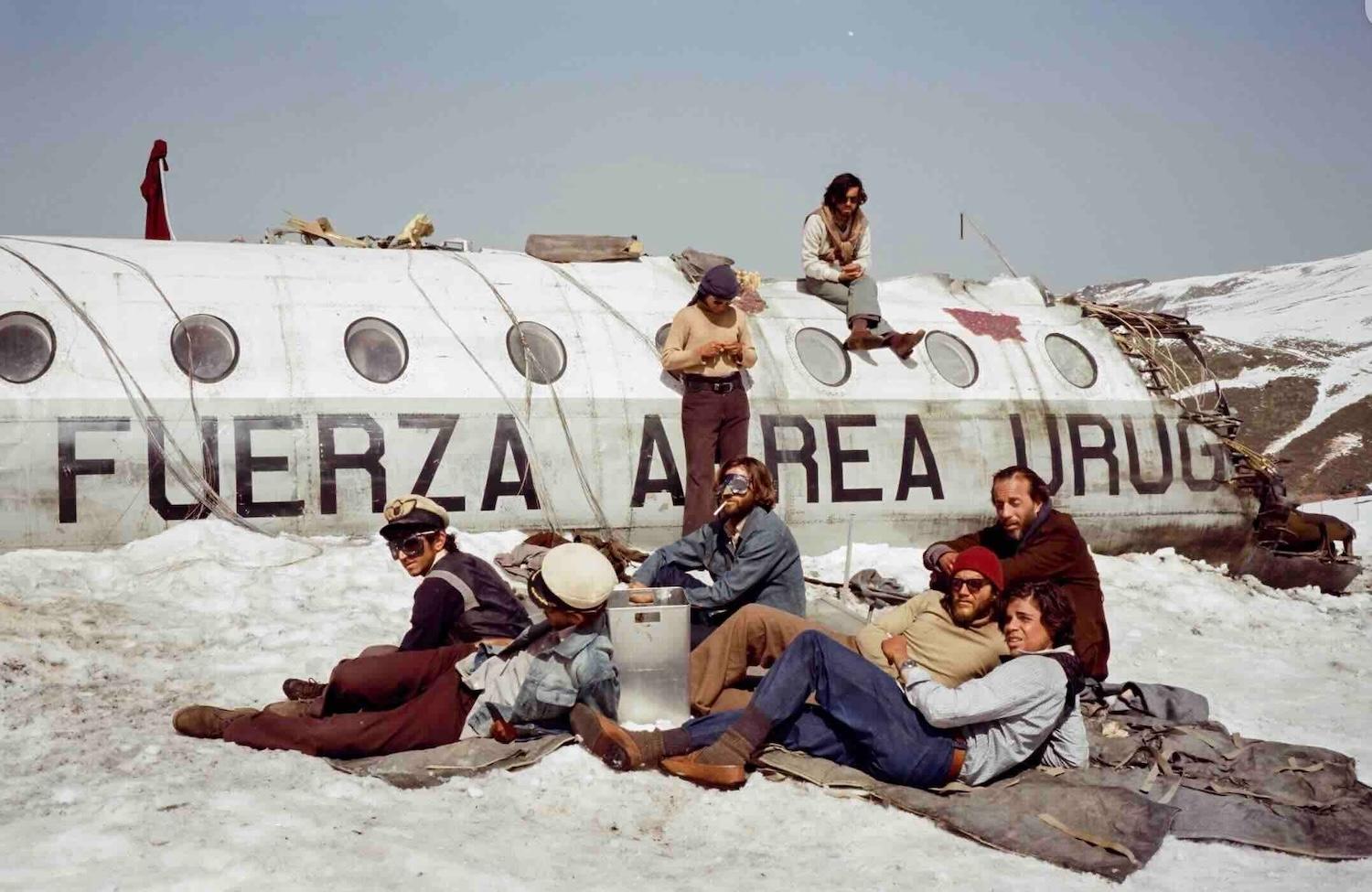 Des personnes sont assises devant une carcasse d'avion. 